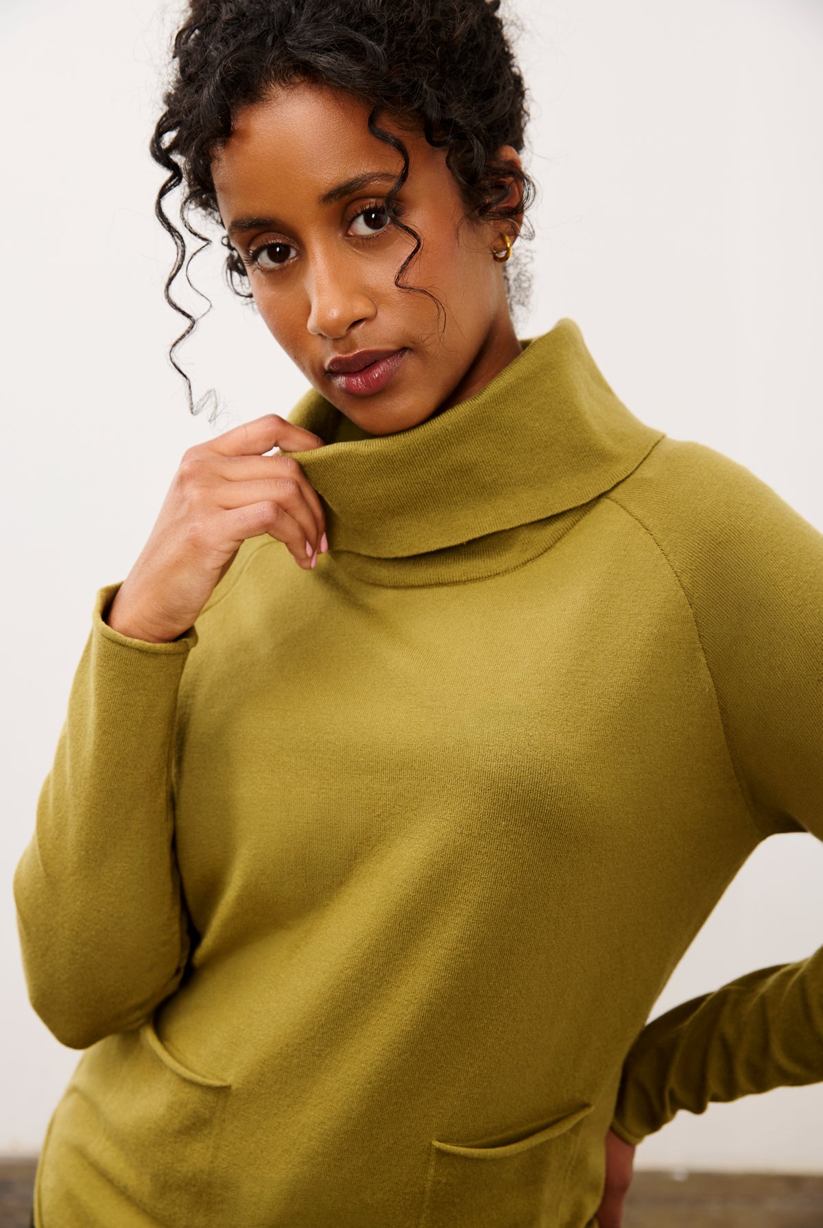 Close-up of olive sweater highlighting cowl neck and pocket details by French Dressing Jeans (FDJ)