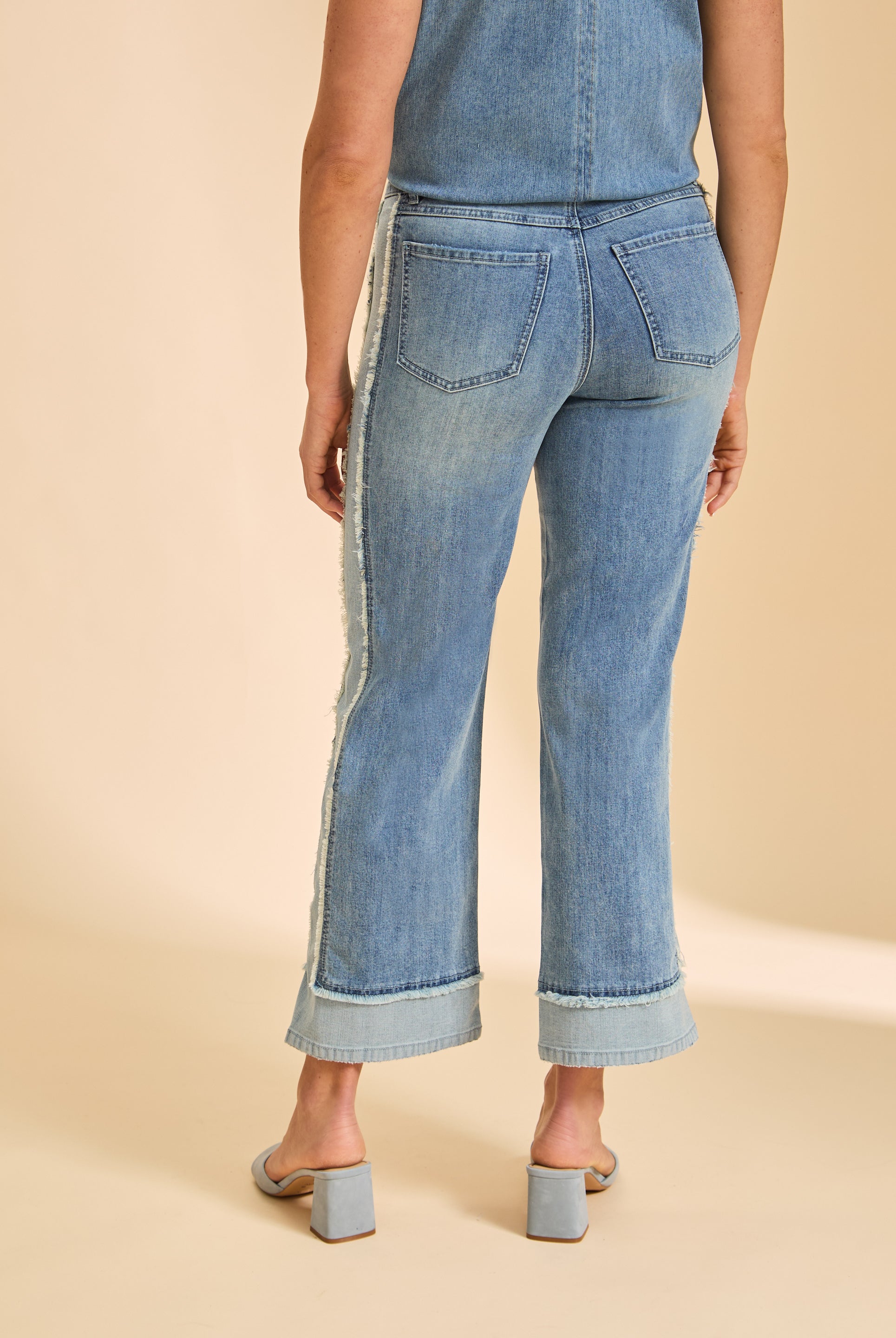 Back view of Olivia wide ankle denim in light wash showing back patch pockets and frayed side seams by French Dressing Jeans (FDJ)