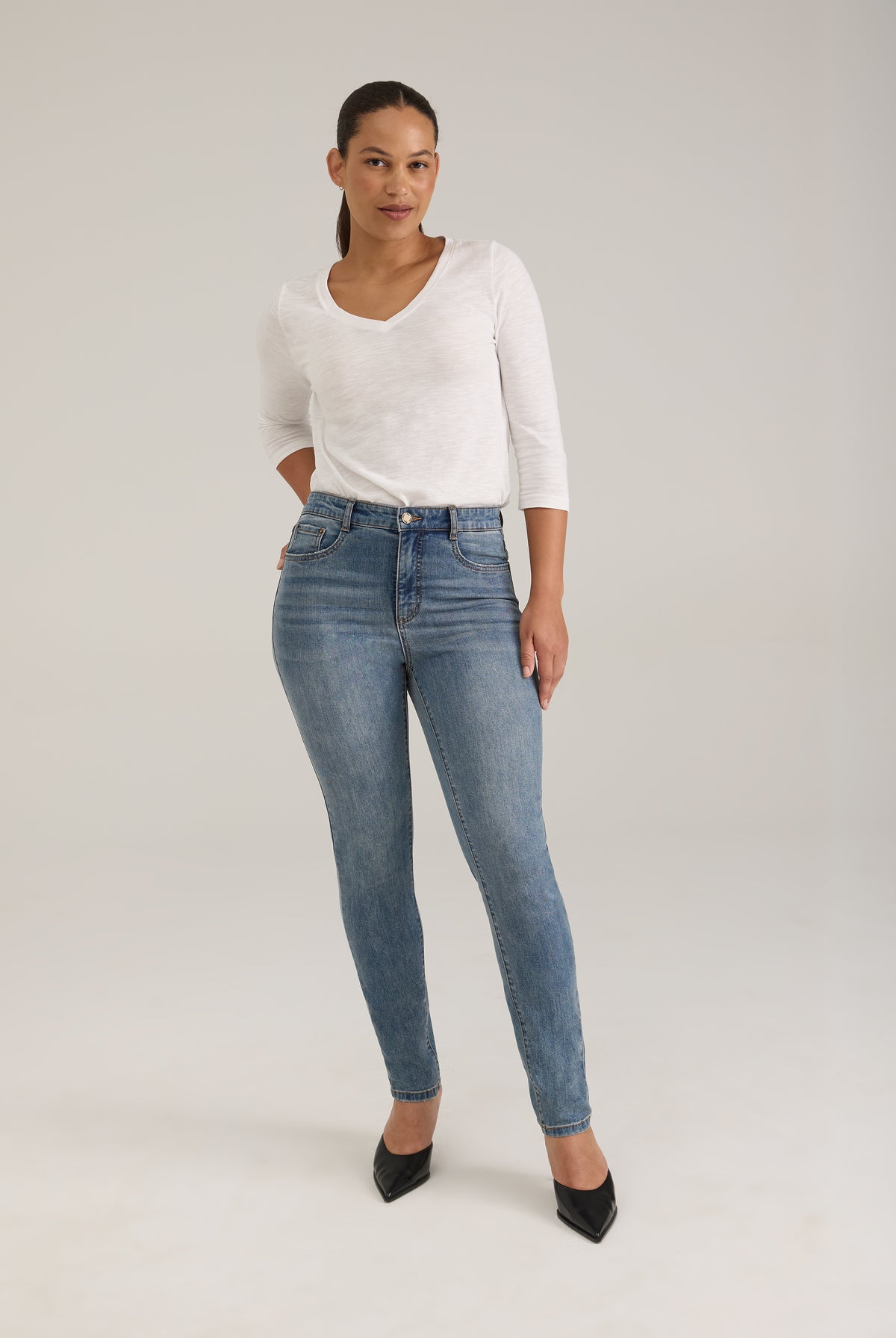 Full view of woman in light wash slim leg jeans with high-rise fit by French Dressing Jeans (FDJ)