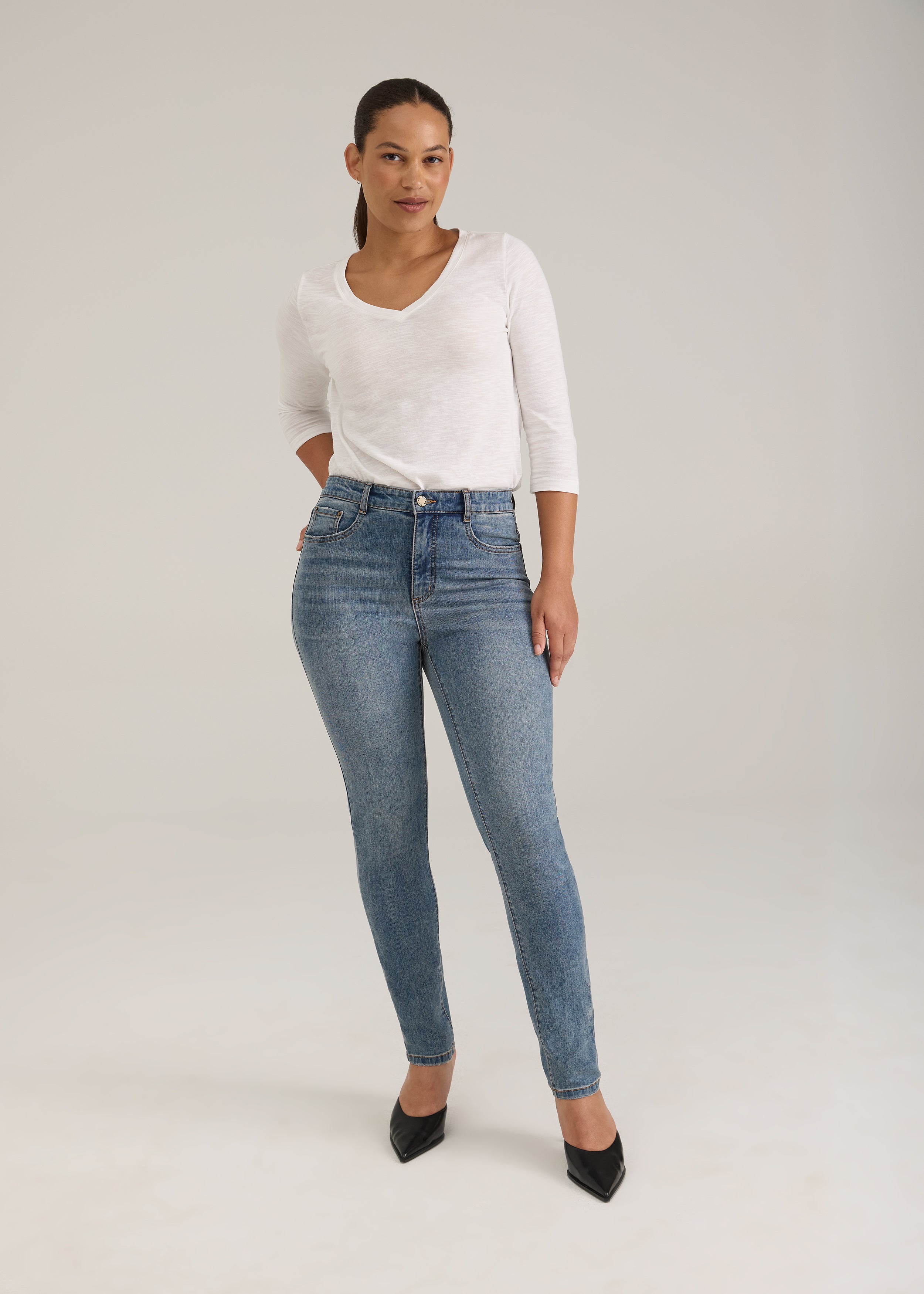 Full view of woman in light wash slim leg jeans with high-rise fit by French Dressing Jeans (FDJ)
