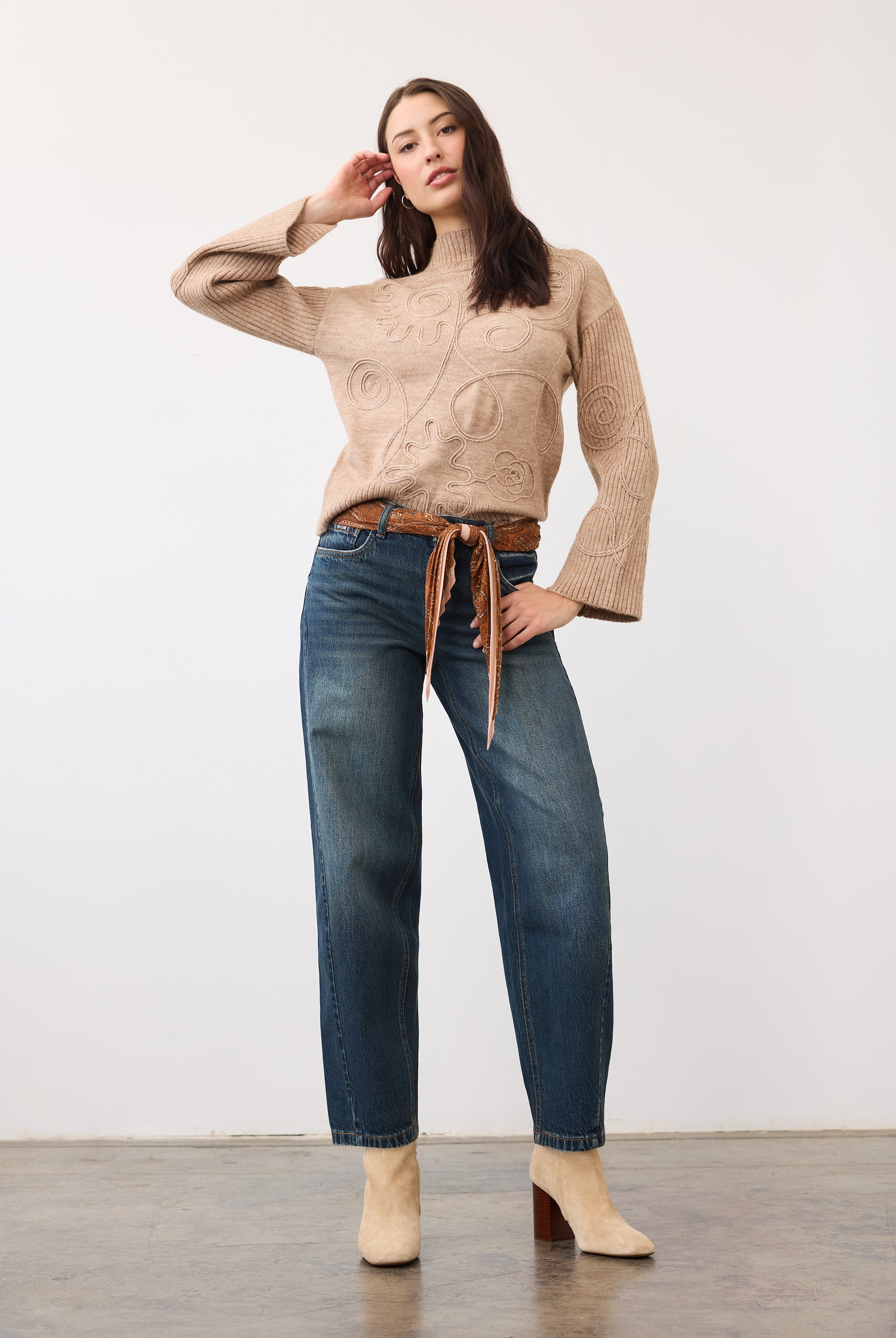 Full view of model in medium blue jeans styled with a belt and boots by French Dressing Jeans (FDJ)