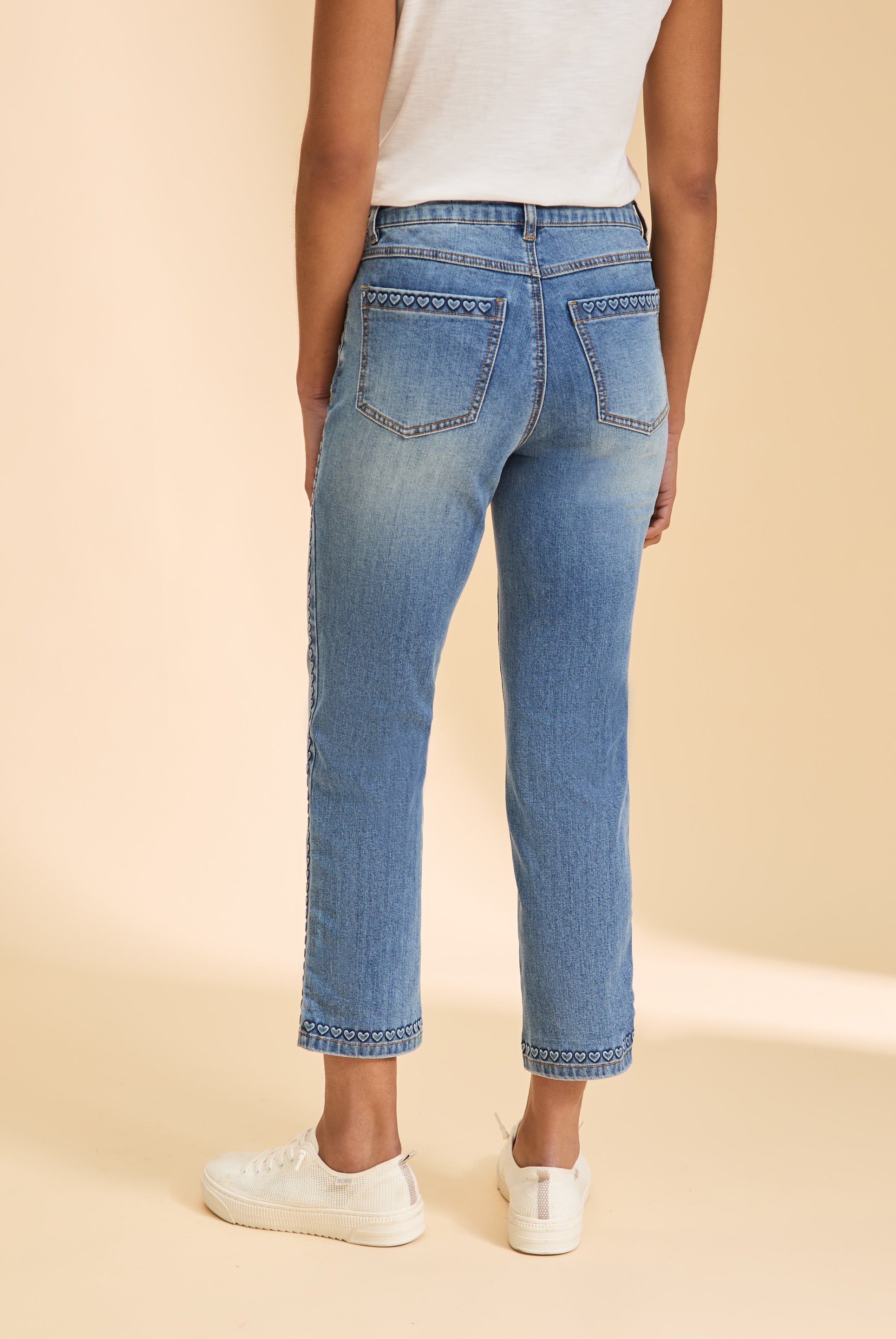 Back view of light wash straight ankle jeans with heart pattern on pockets by French Dressing Jeans (FDJ)