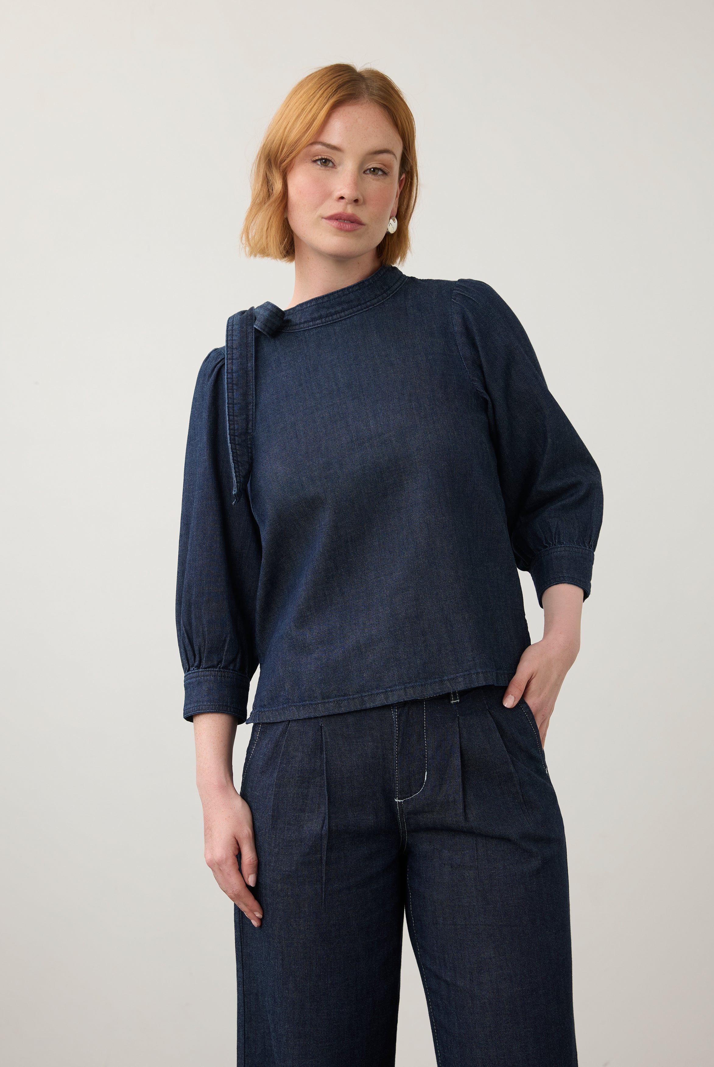 Front view of dark wash puff-sleeve top with wide-leg pants showing pleated waist by French Dressing Jeans (FDJ)