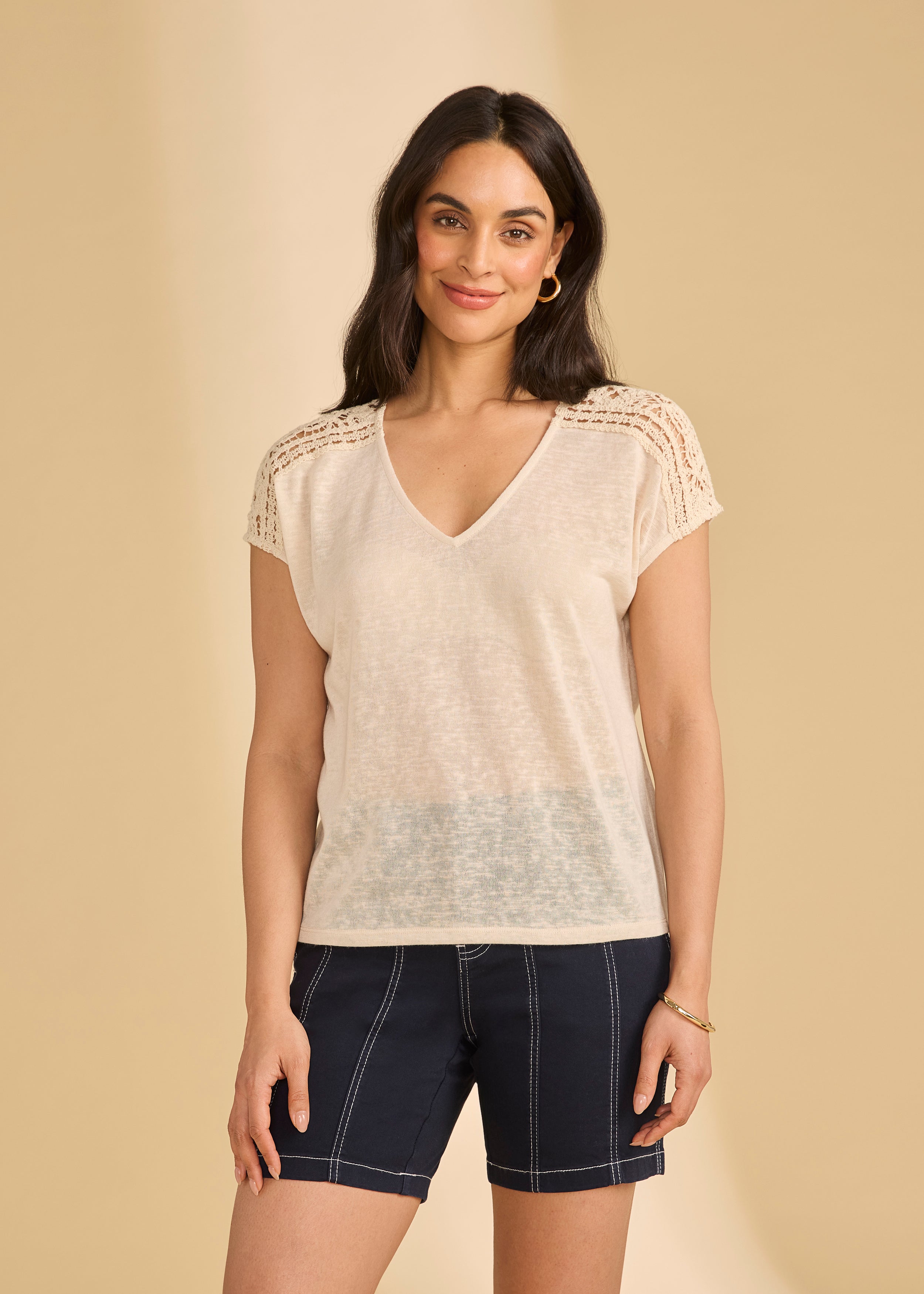 Front view of beige V-neck top with crochet shoulders paired with navy shorts by French Dressing Jeans (FDJ)