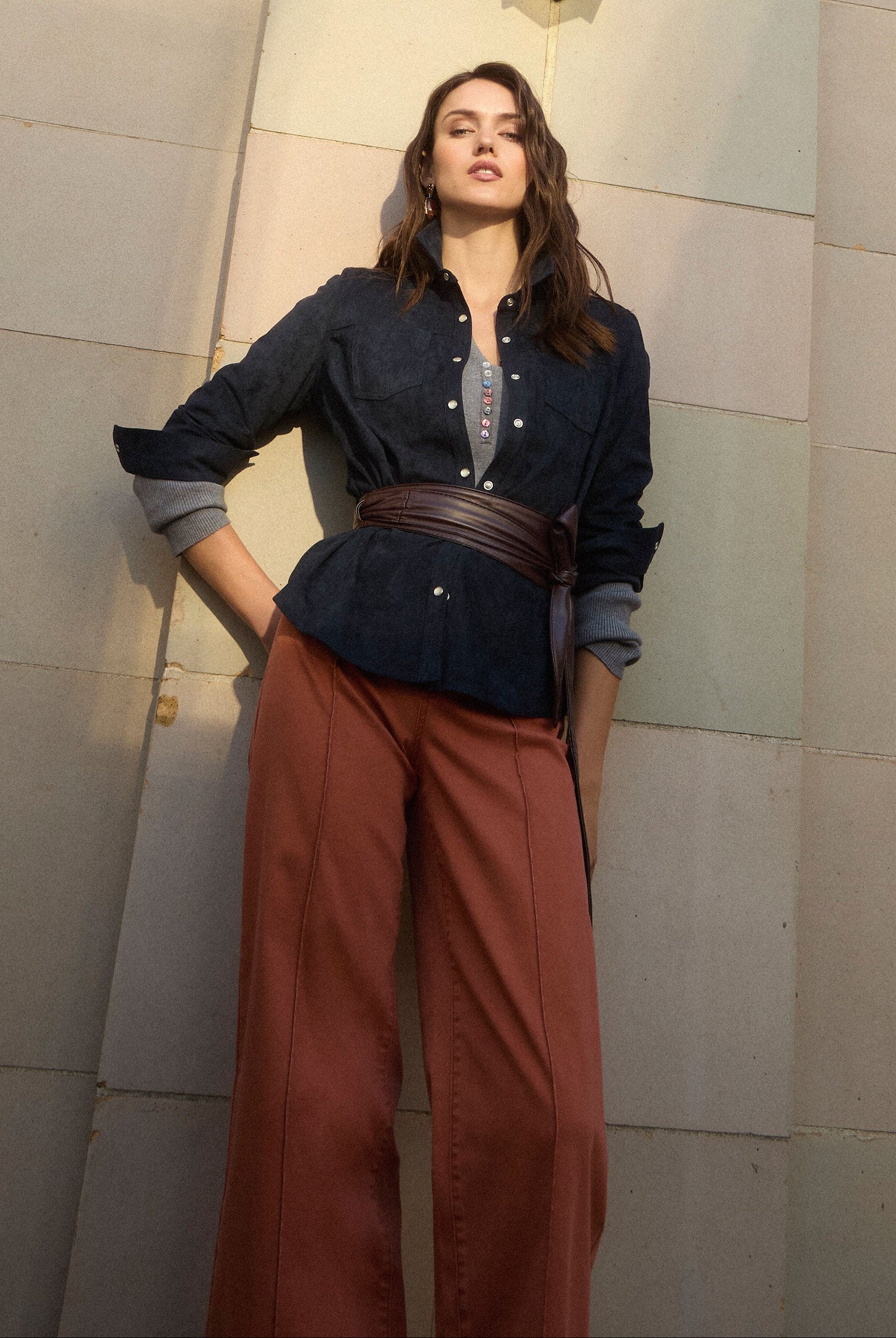 Outdoor shot of model in terracotta wide-leg denim under architectural backdrop by French Dressing Jeans (FDJ) par French Dressing Jeans (FDJ)