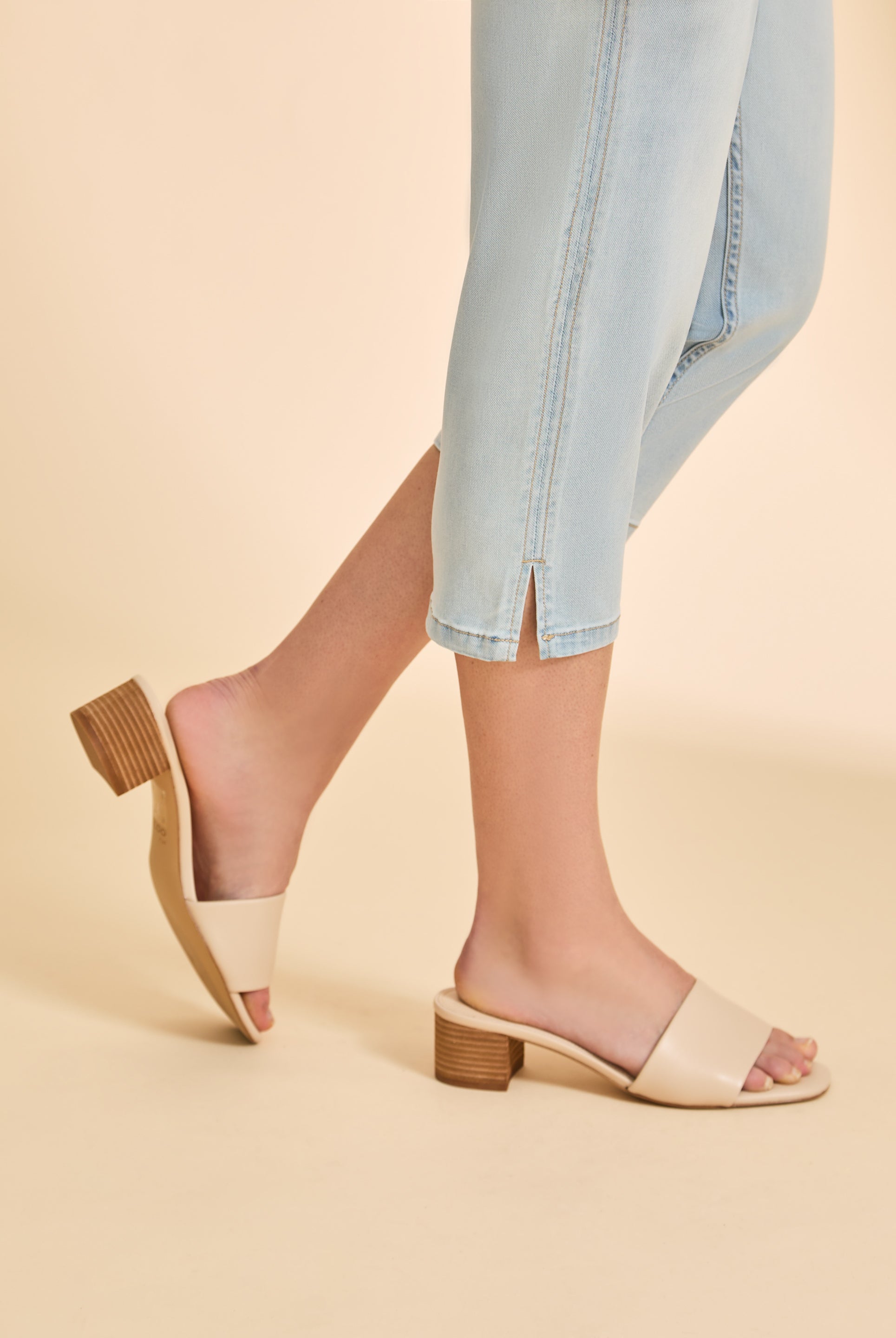 Detail shot of hemline slit on light wash cropped denim pants by French Dressing Jeans (FDJ)