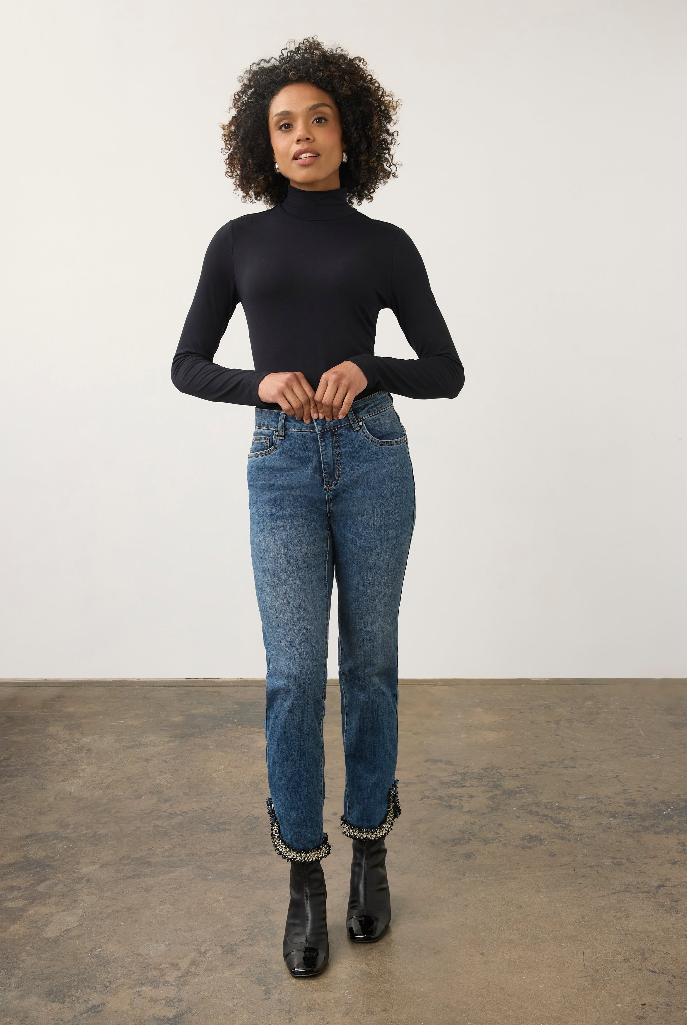 Full body view of black turtleneck top paired with slim-fit jeans by French Dressing Jeans (FDJ)