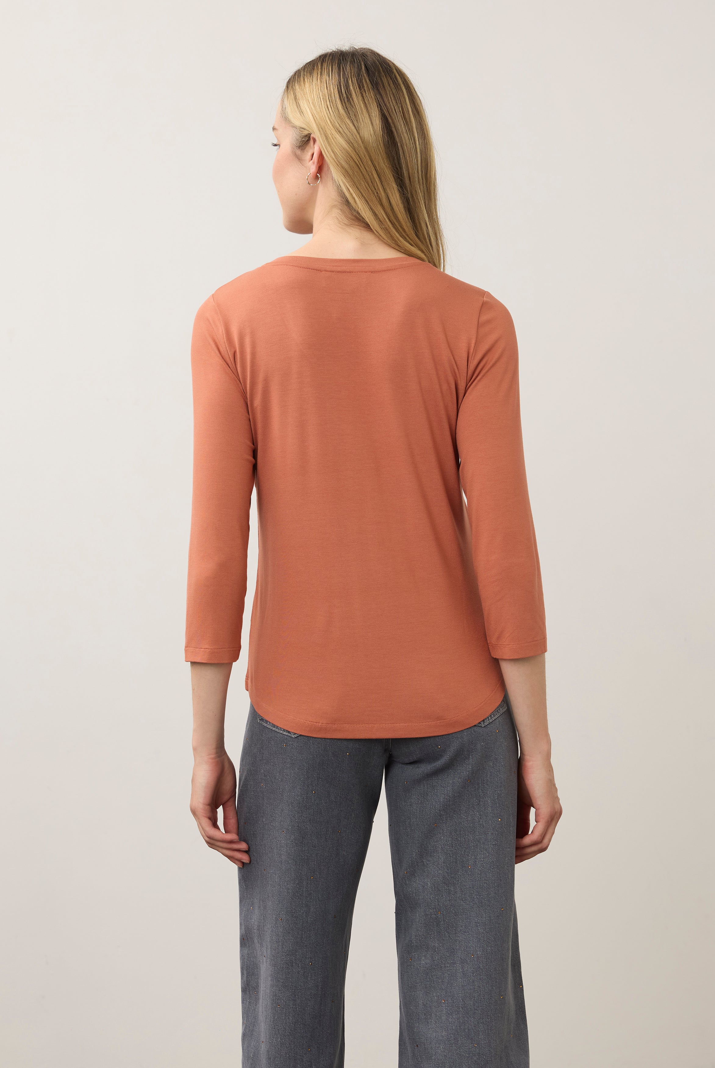 Back view of orange V-neck top featuring simple elegance and smooth silhouette by French Dressing Jeans (FDJ)