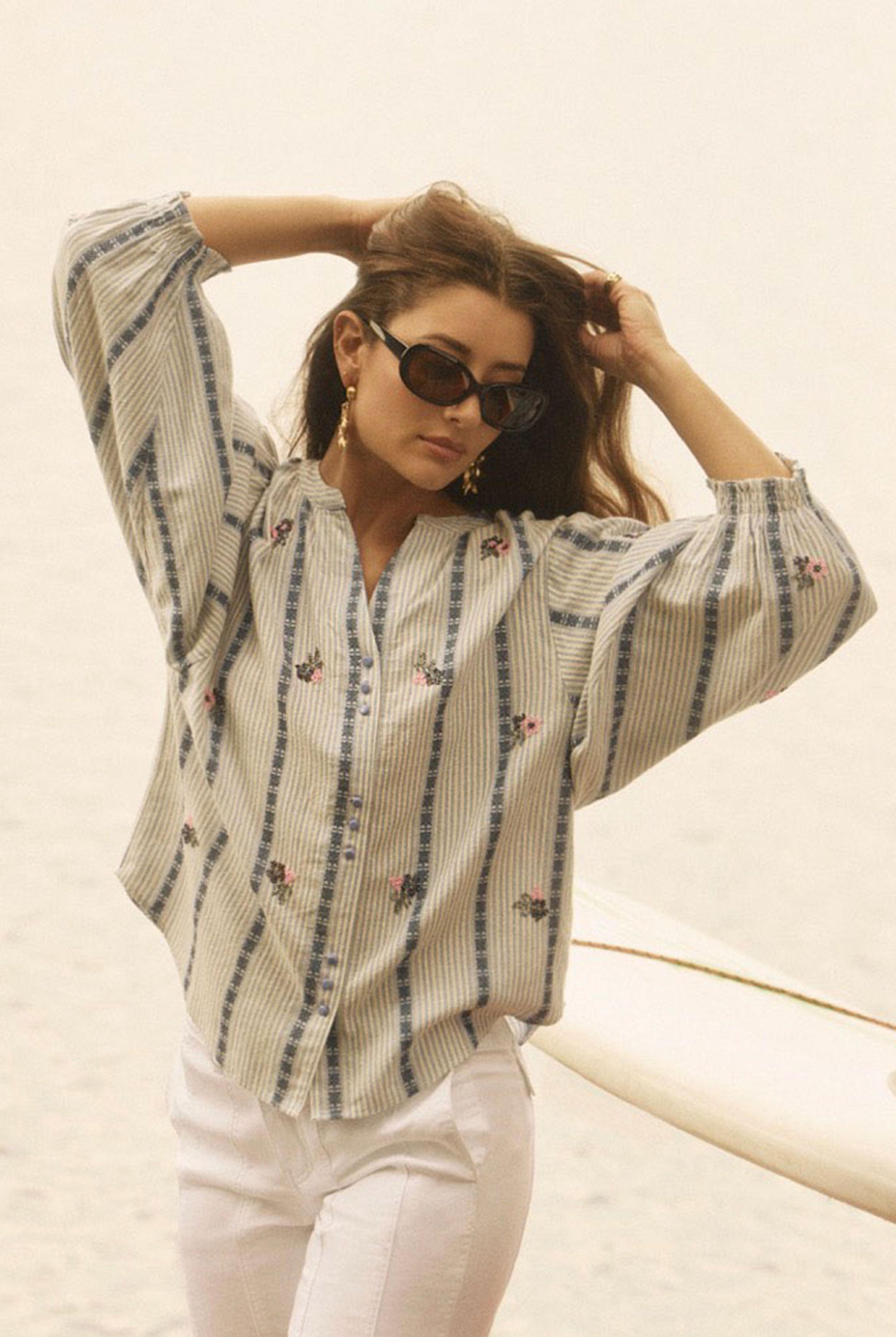 Outdoor view of woman in striped shirt with floral accents and sunglasses by French Dressing Jeans (FDJ)