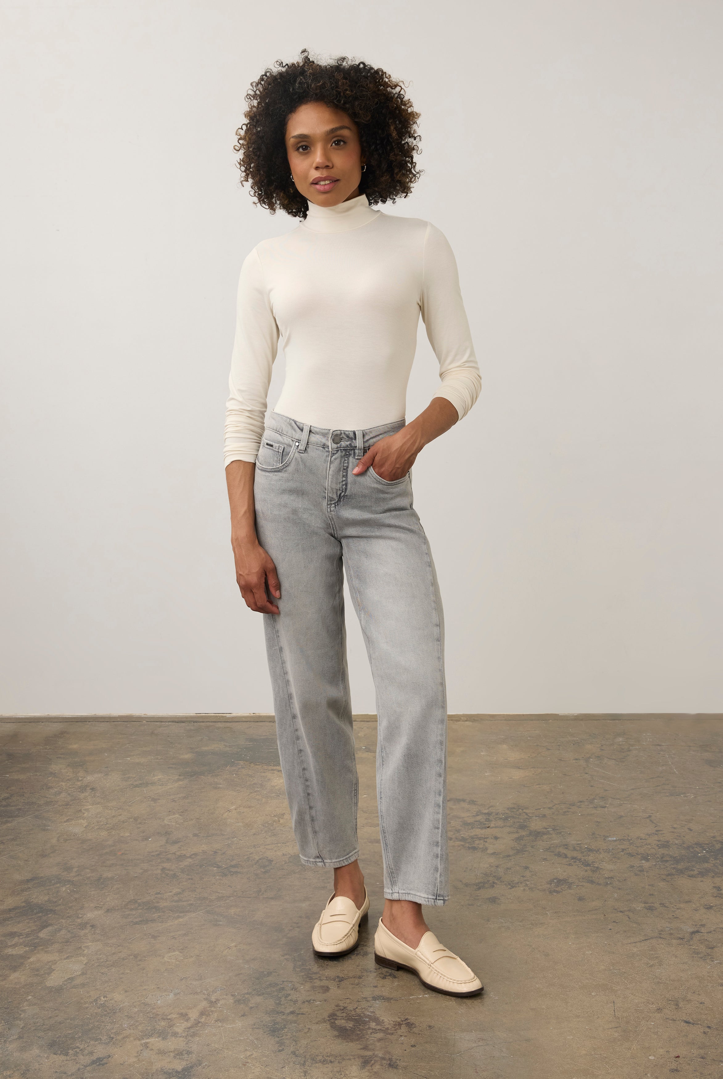 Full body view of cream turtleneck top paired with straight-leg jeans by French Dressing Jeans (FDJ)