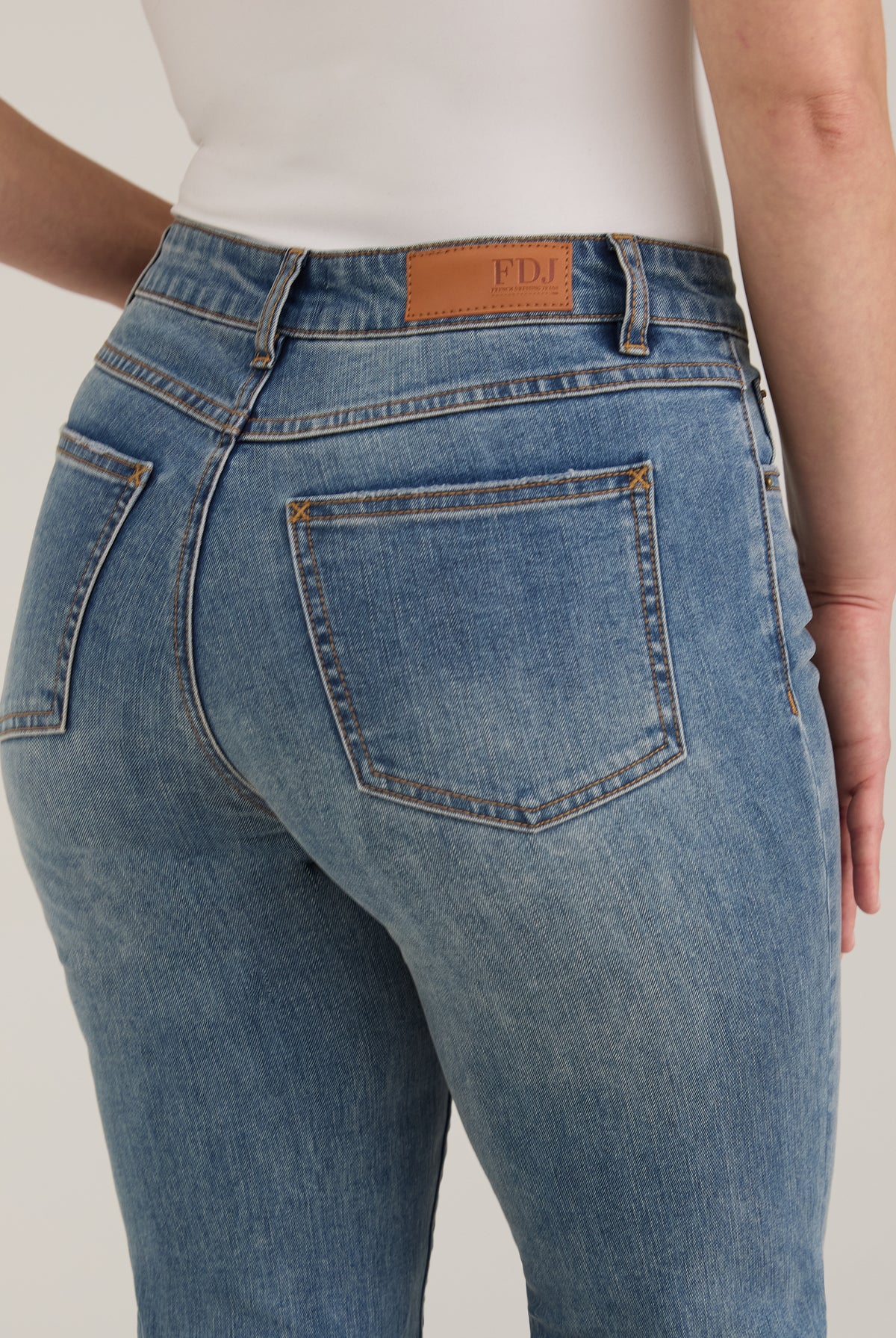 Detail shot of back pockets and waistline on light wash Olivia straight leg denim by French Dressing Jeans (FDJ)