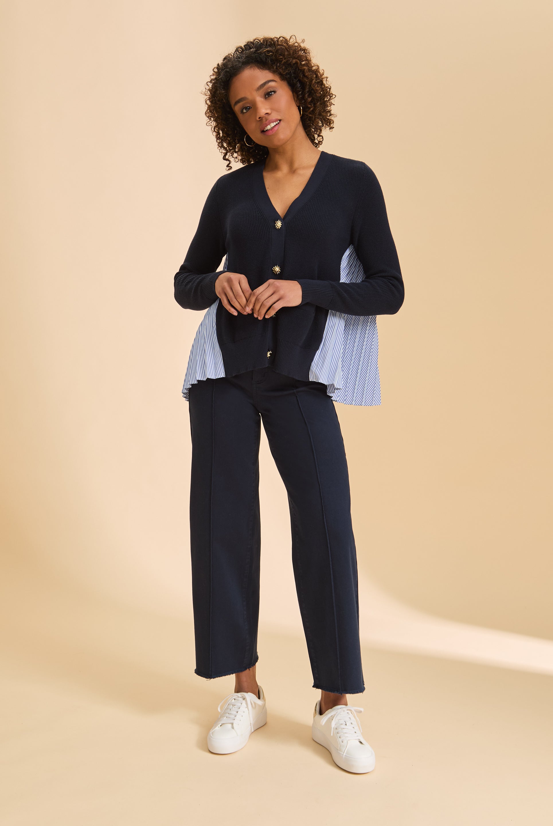 Full view of navy cardigan paired with dark pants and white sneakers by French Dressing Jeans (FDJ)