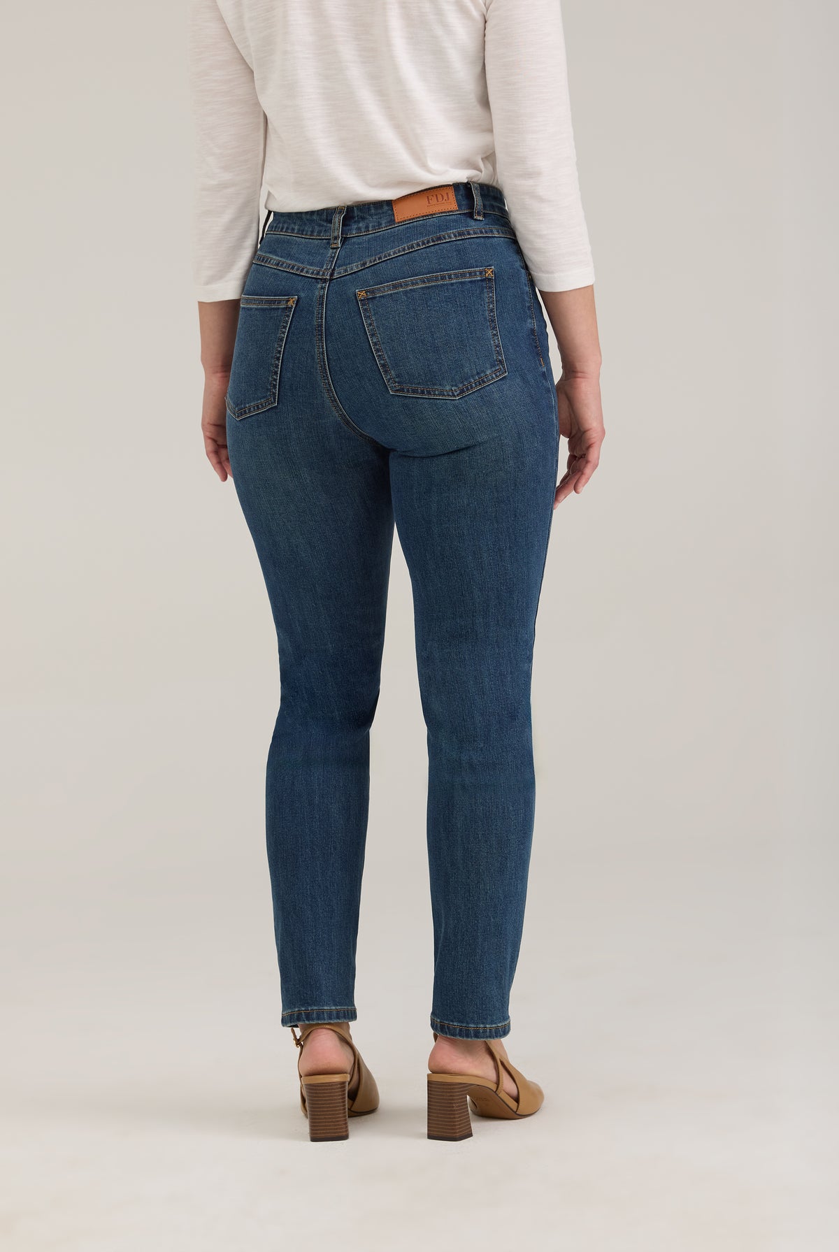 Back view of dark wash jeans showing back patch pockets and snug fit by French Dressing Jeans (FDJ)