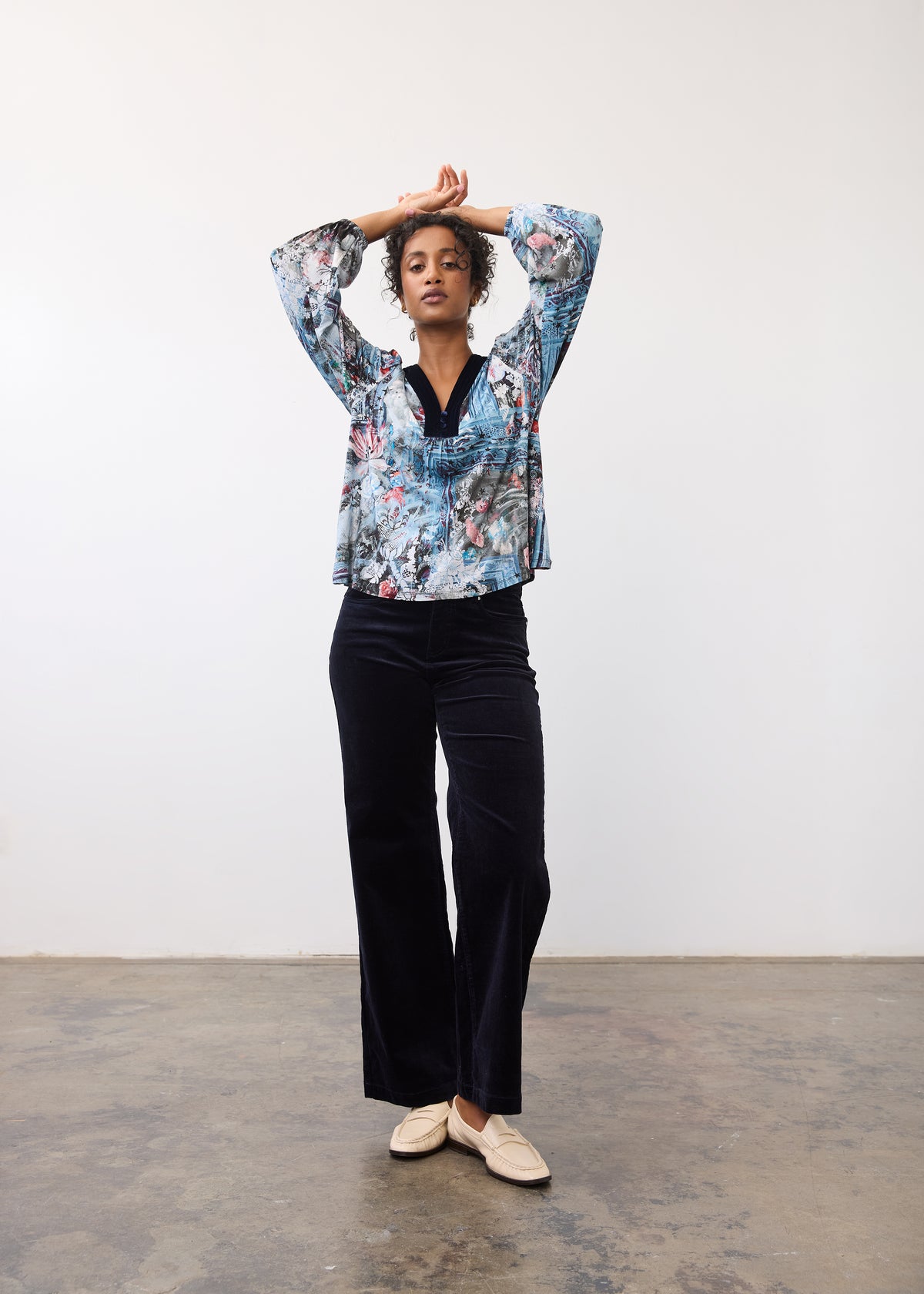 Full body view of Indigo Gallery V-neck top with abstract print, paired with dark pants by French Dressing Jeans (FDJ)