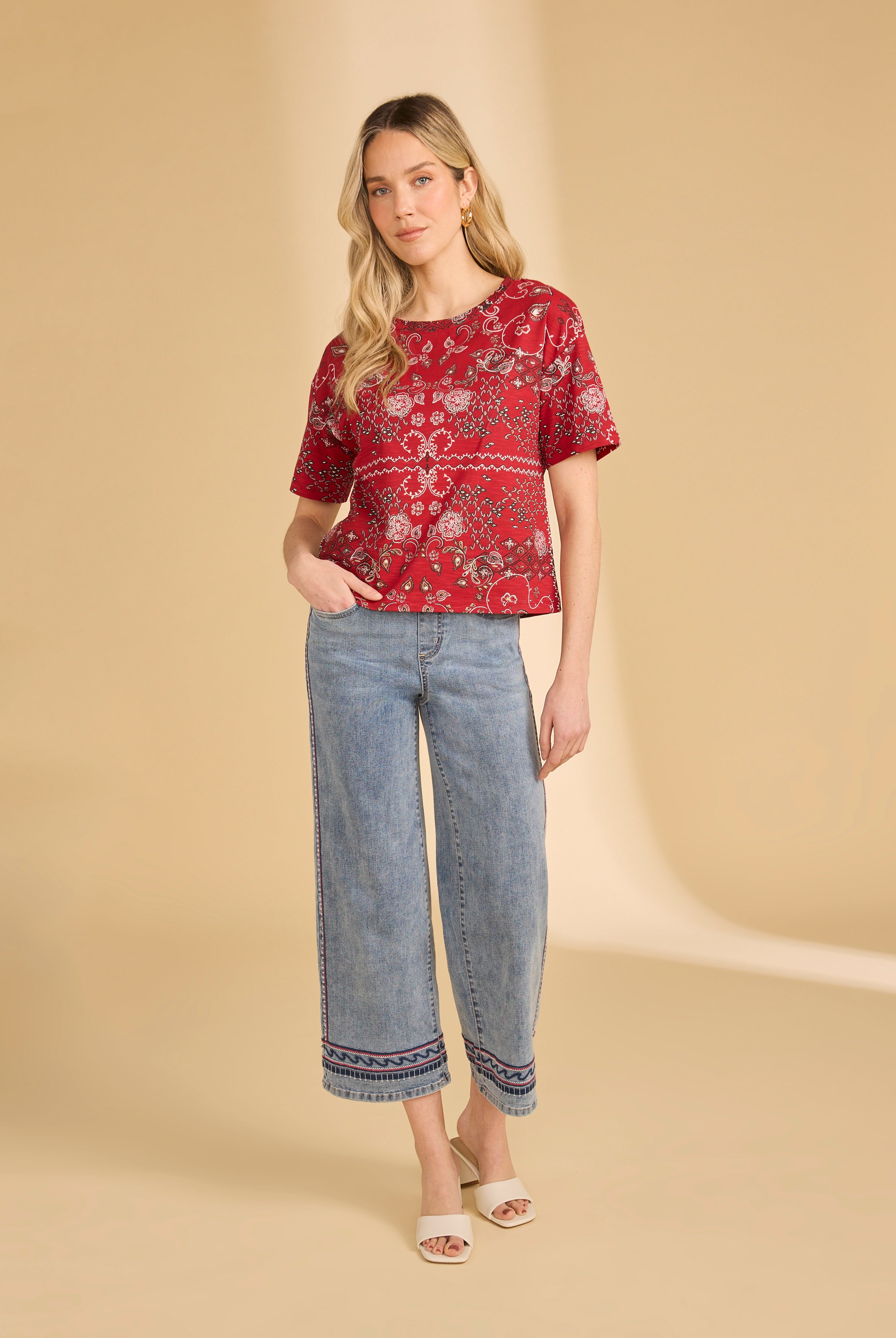 Full body view of red Polynesian block print top with light blue jeans and white sandals by French Dressing Jeans (FDJ)