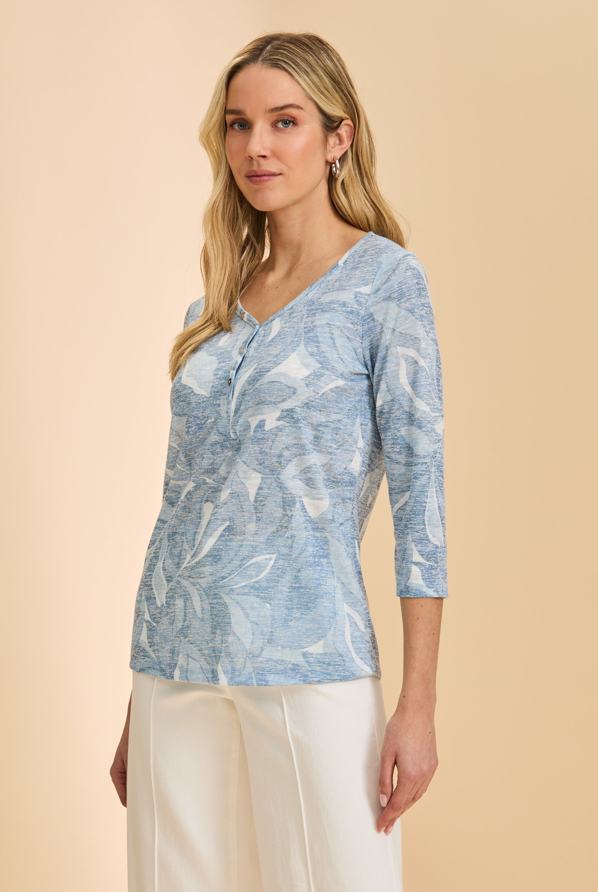 Side view of light blue floral top with 3/4 sleeves and V-neck design paired with white pants by French Dressing Jeans (FDJ)