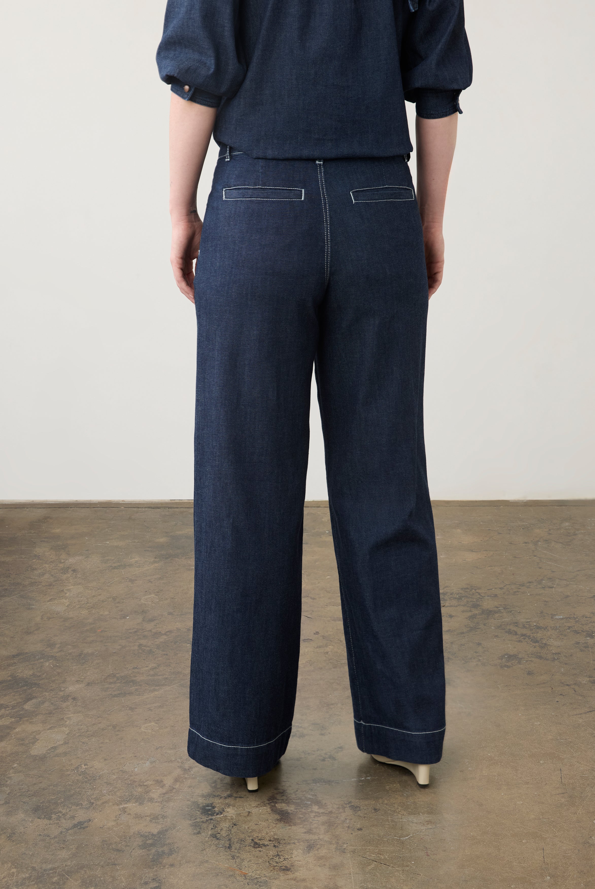Back view of dark wash wide-leg pants with welt pockets and cropped top by French Dressing Jeans (FDJ)