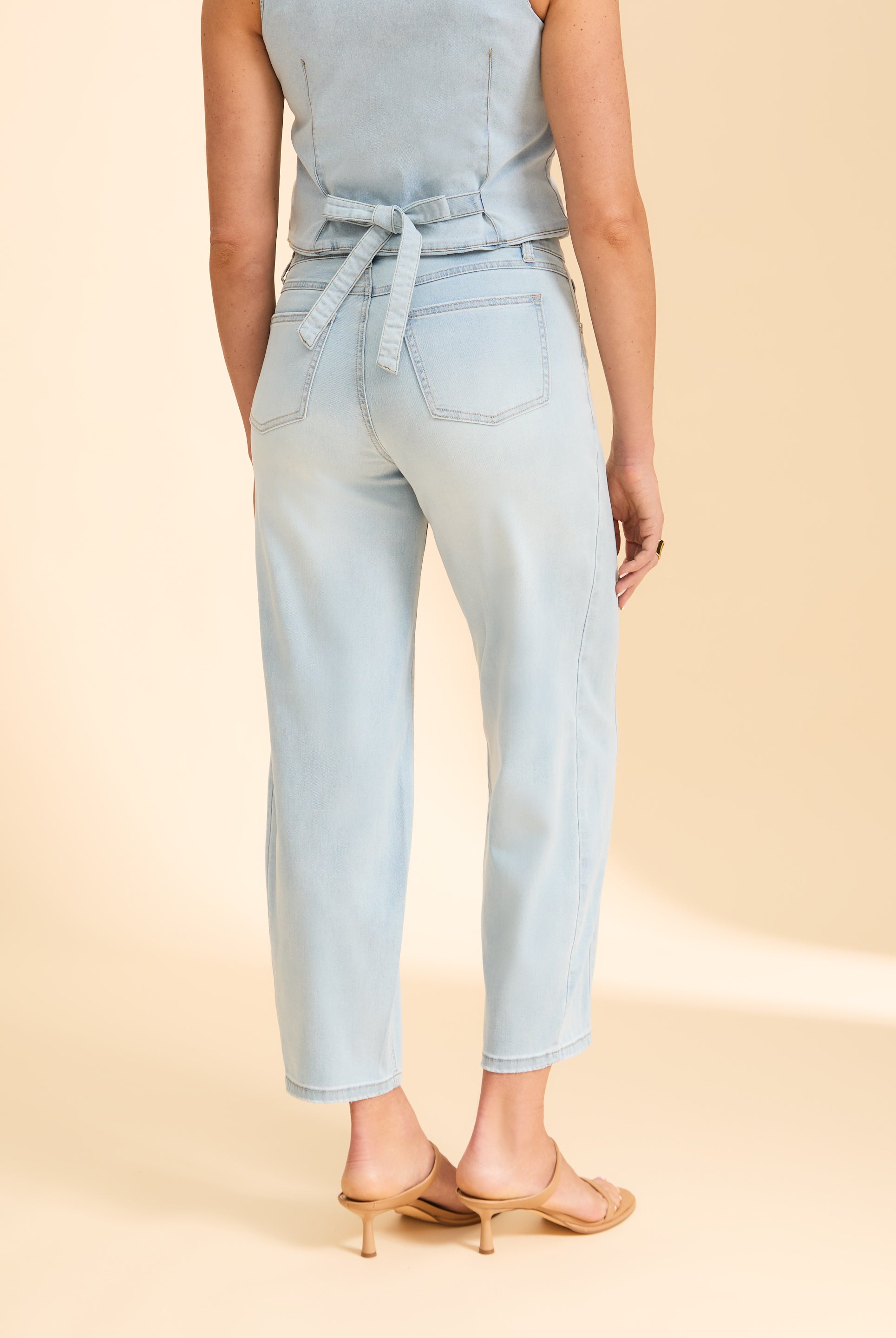 Back view of light wash denim jeans with tied waist detail and pockets by French Dressing Jeans (FDJ)