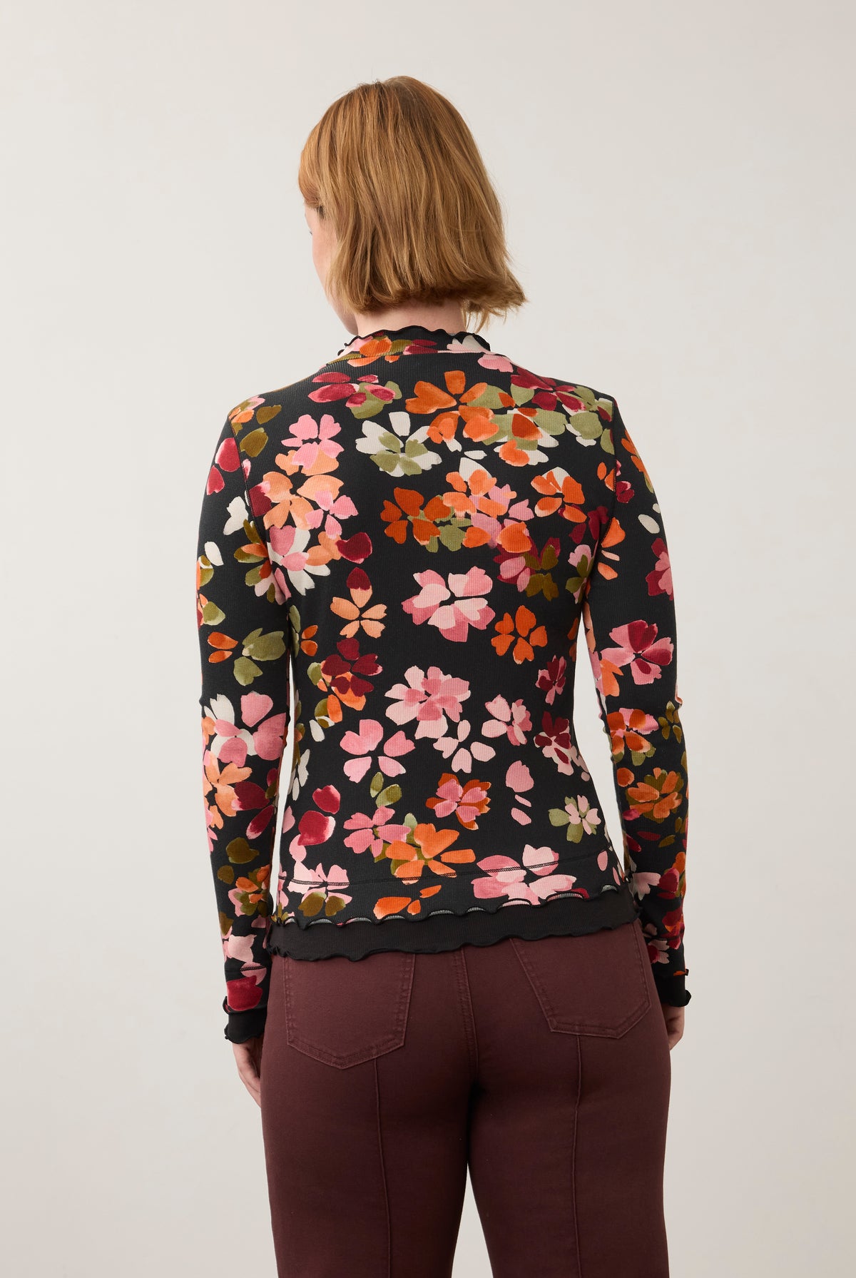 Back view of vibrant floral top, highlighting seamless design and ruffled edges by French Dressing Jeans (FDJ)