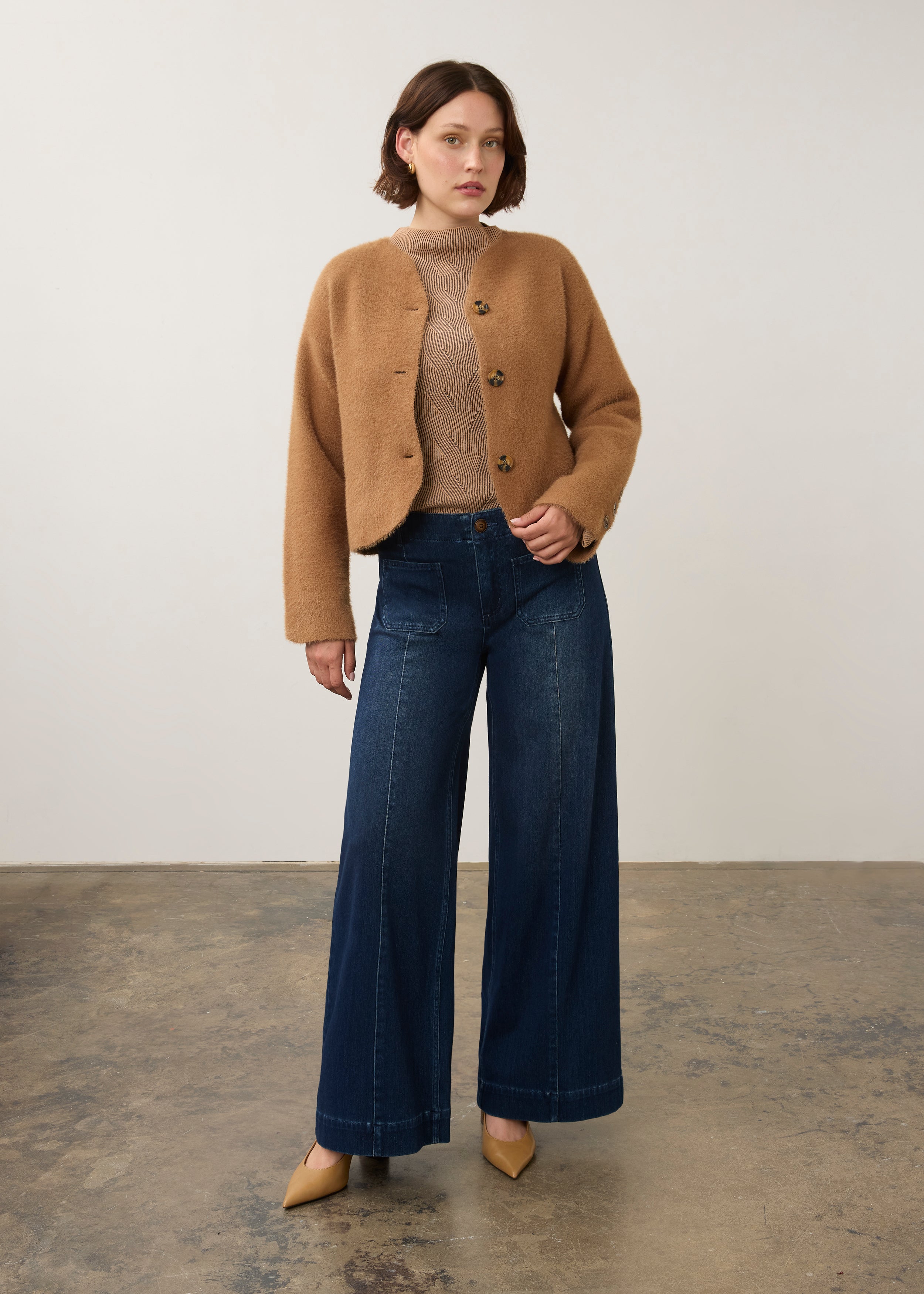 Full-body shot of model in camel knit cardigan styled with dark jeans by French Dressing Jeans (FDJ)