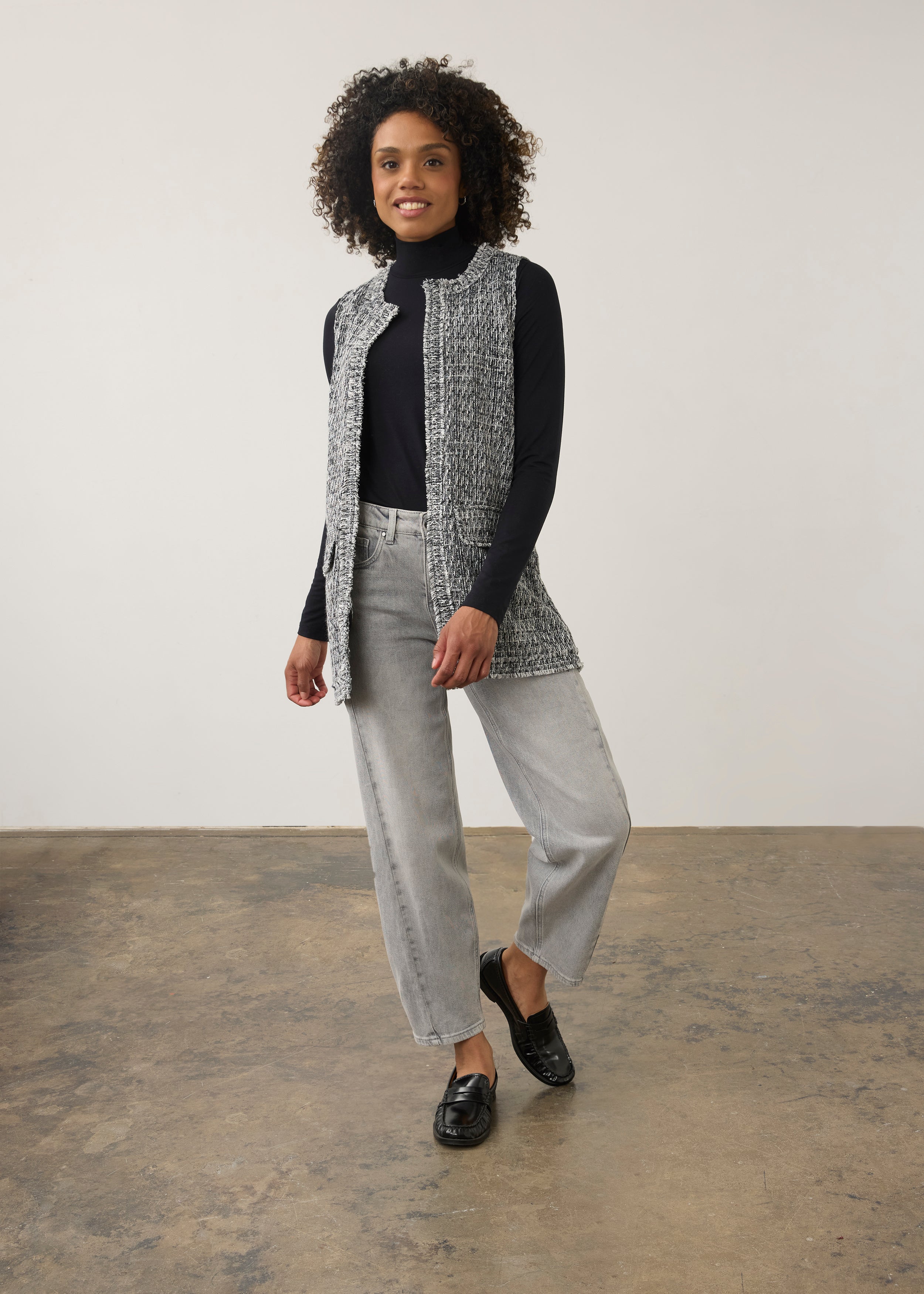 Full-body shot of model in black and white textured vest styled with gray jeans by French Dressing Jeans (FDJ)