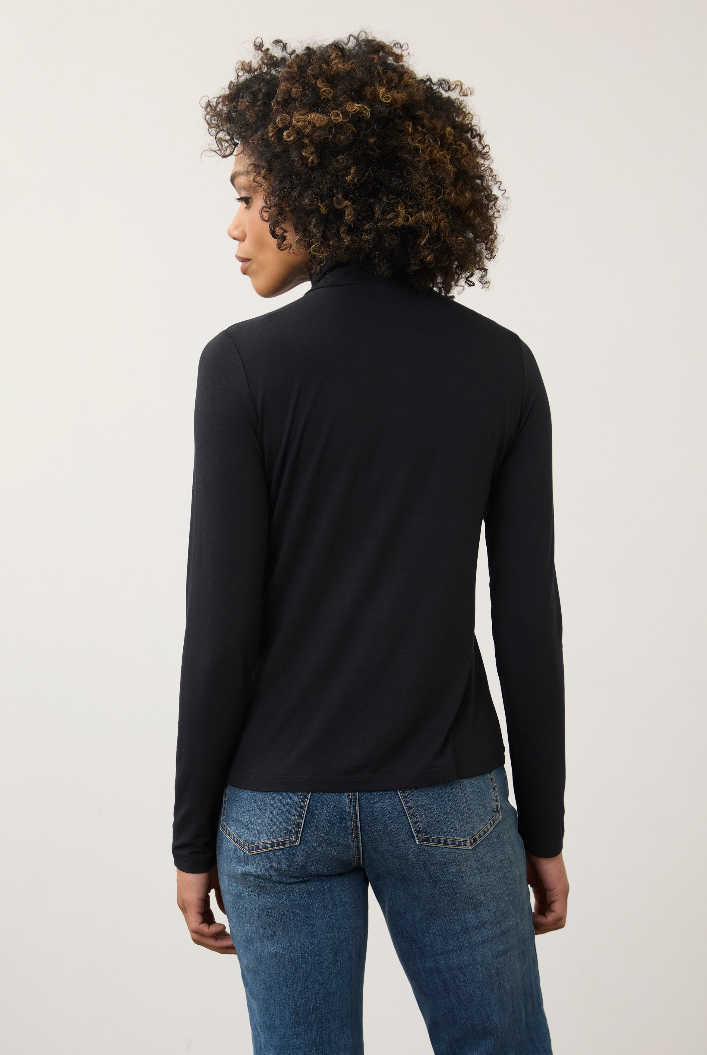 Back view of black turtleneck top highlighting smooth fabric and seamless design by French Dressing Jeans (FDJ)