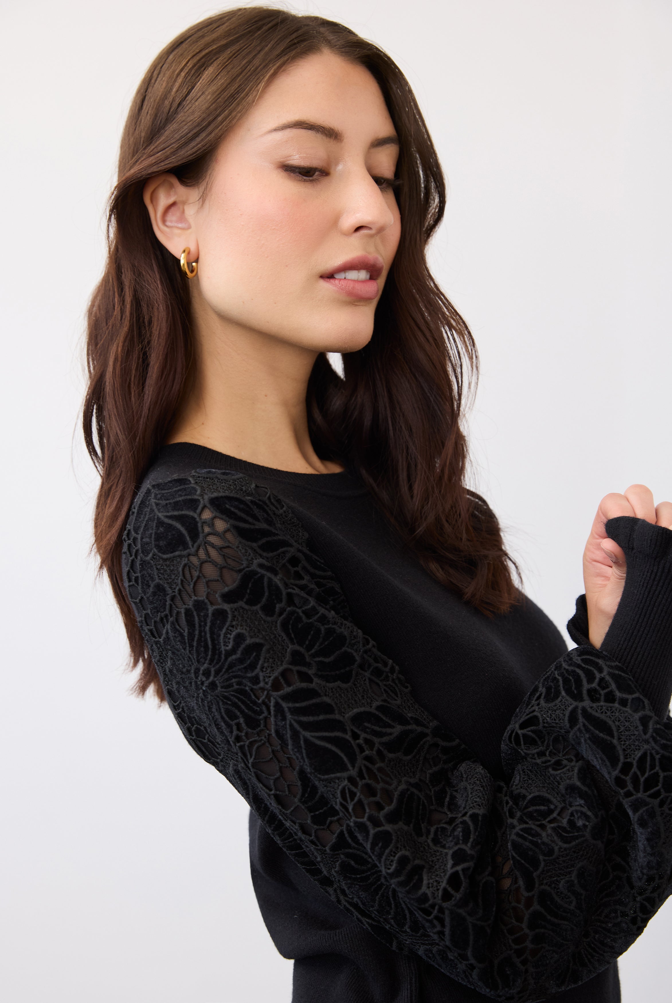 Close-up of floral lace and velvet cut-out sleeve on black sweater by French Dressing Jeans (FDJ)