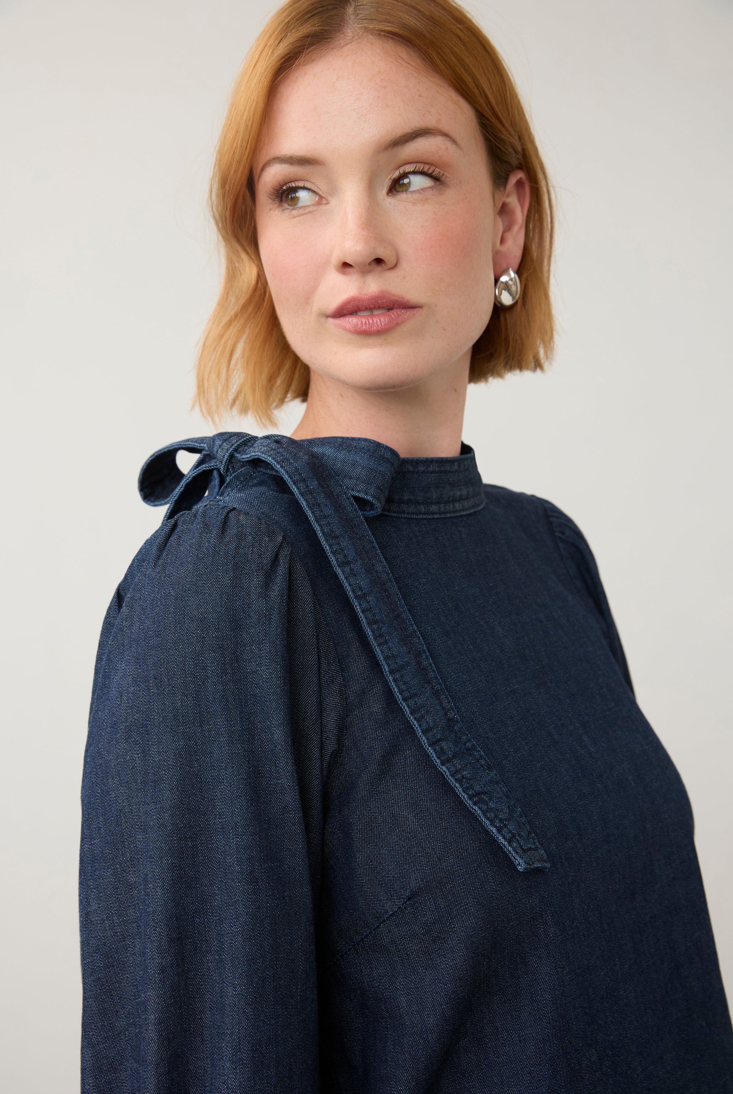 Close-up of dark wash puff-sleeve top with shoulder bow tie detail by French Dressing Jeans (FDJ)