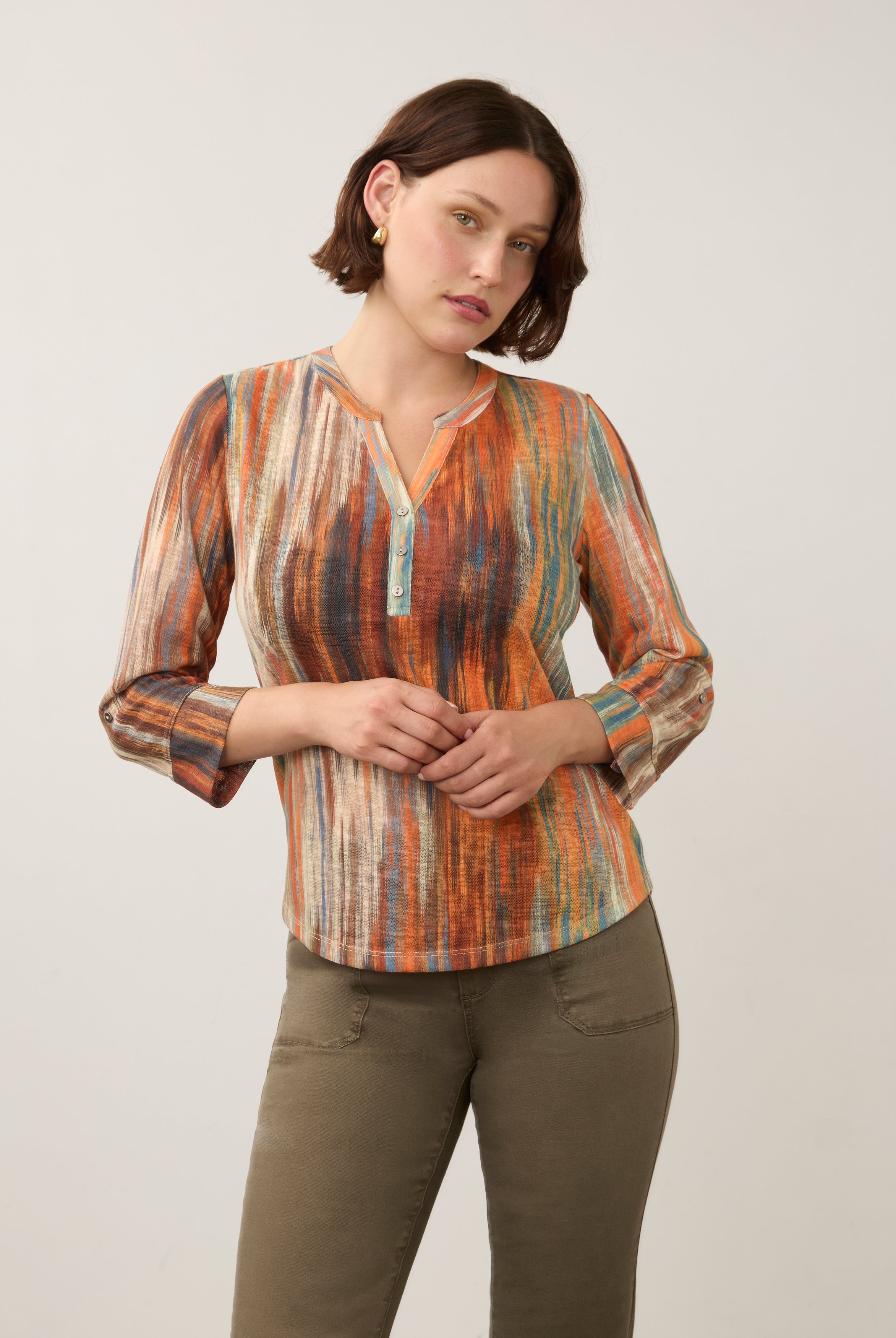 Front view of 3/4 sleeve Henley top in Heat color, button-front placket, paired with olive pants by French Dressing Jeans (FDJ)
