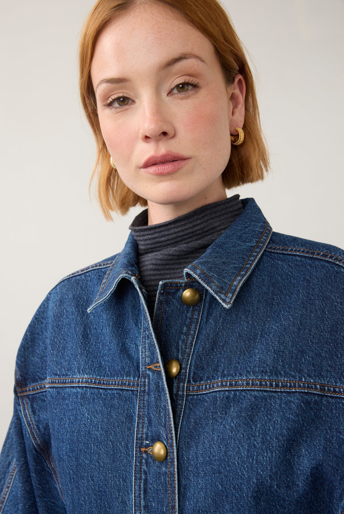 Close-up of oversized medium blue utility jacket with brass buttons by French Dressing Jeans (FDJ) par French Dressing Jeans (FDJ)