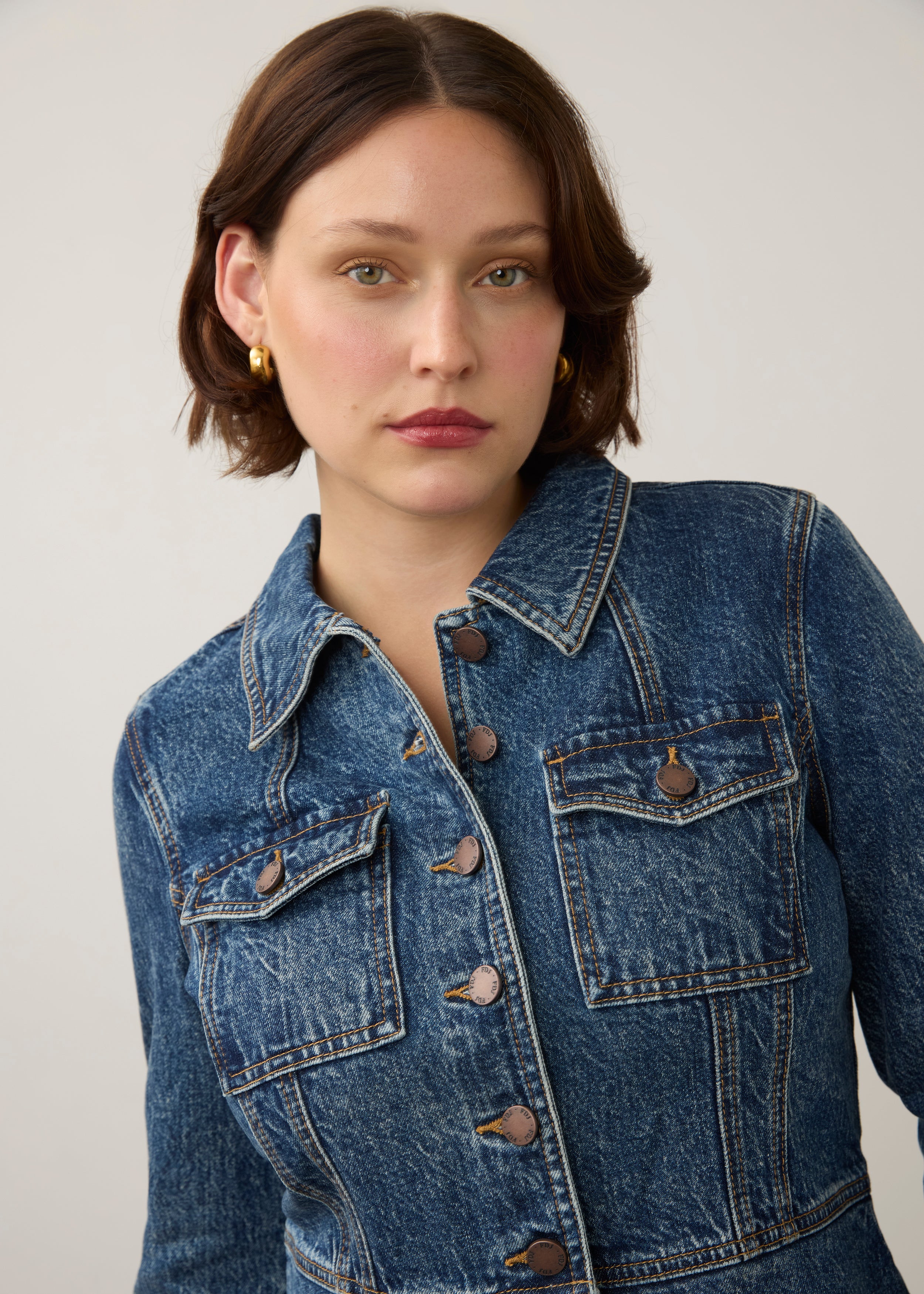 Close-up of medium blue utility jacket highlighting flap pockets and button details by French Dressing Jeans (FDJ) par French Dressing Jeans (FDJ)