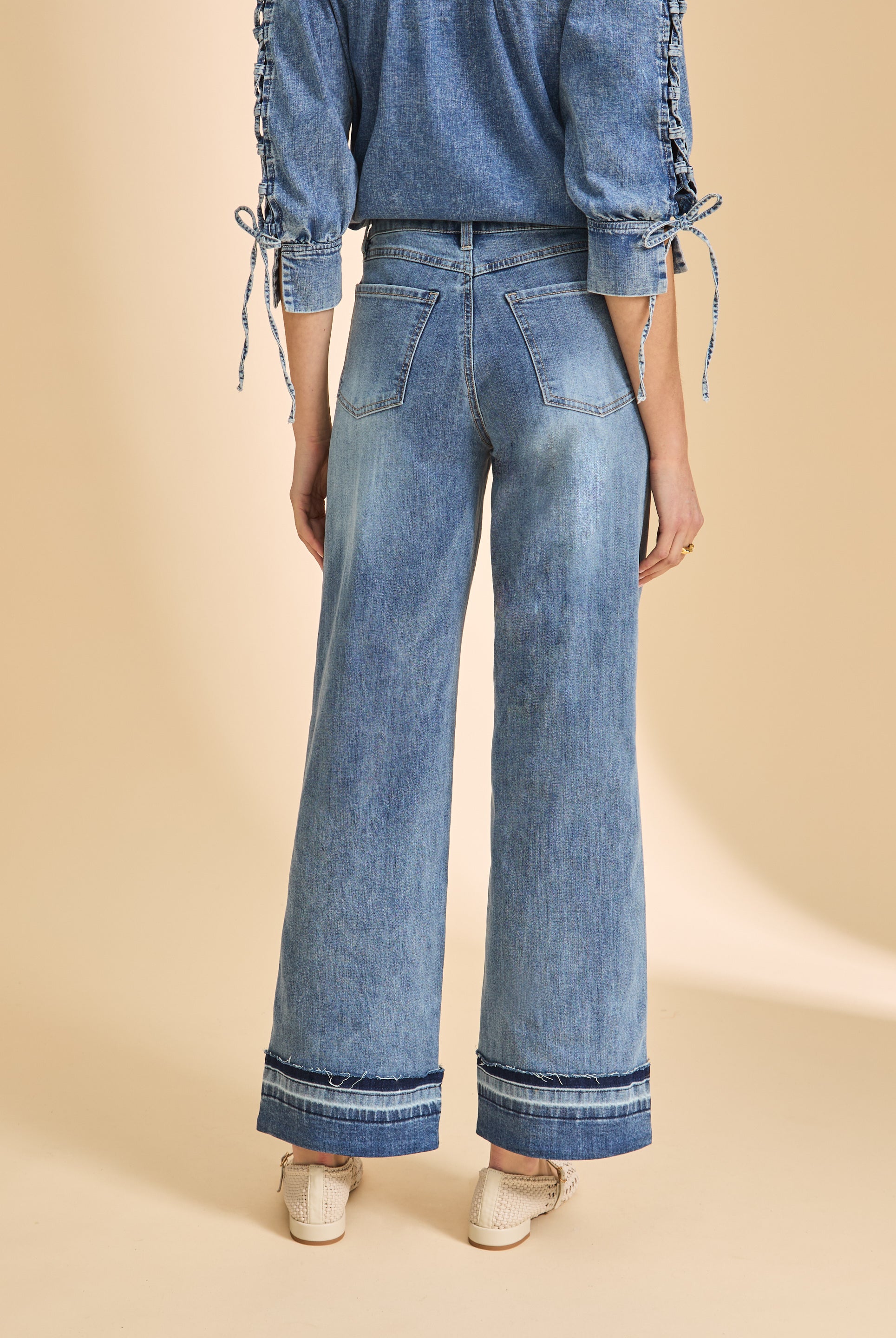 Back view of wide-leg denim with cuffed hem and patch pockets by French Dressing Jeans (FDJ)