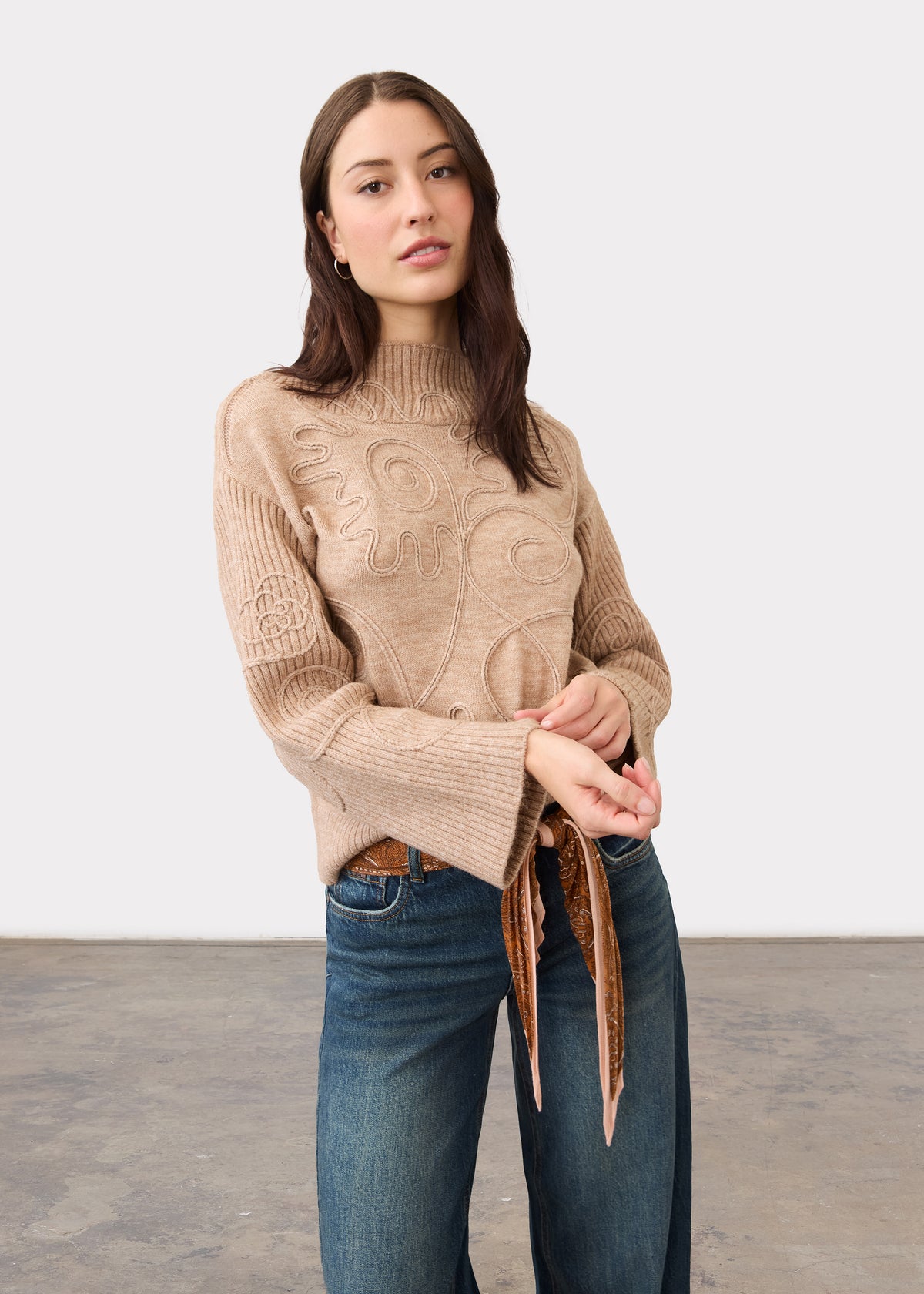 Full view of light camel sweater highlighting abstract embroidery with jeans by French Dressing Jeans (FDJ)