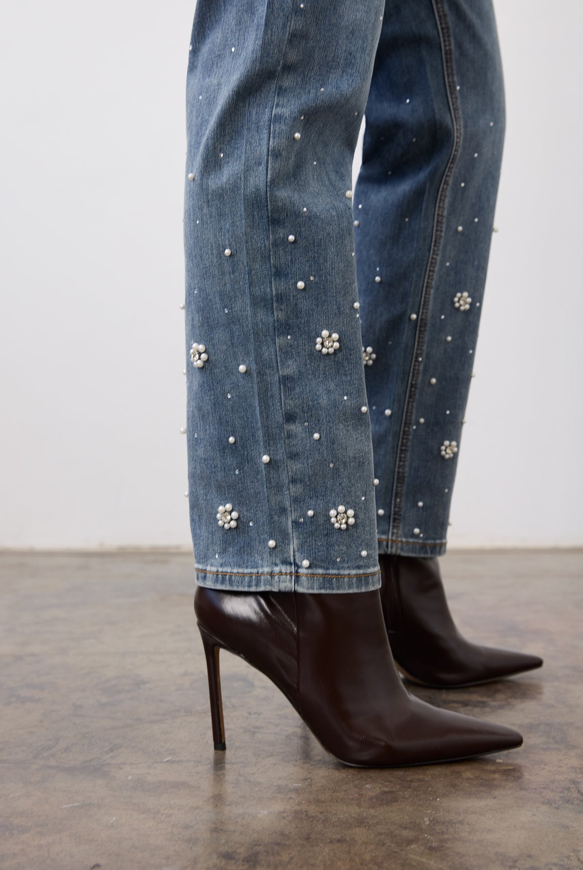 Close-up of indigo jeans fabric showing pearl embellishments on leg by French Dressing Jeans (FDJ)