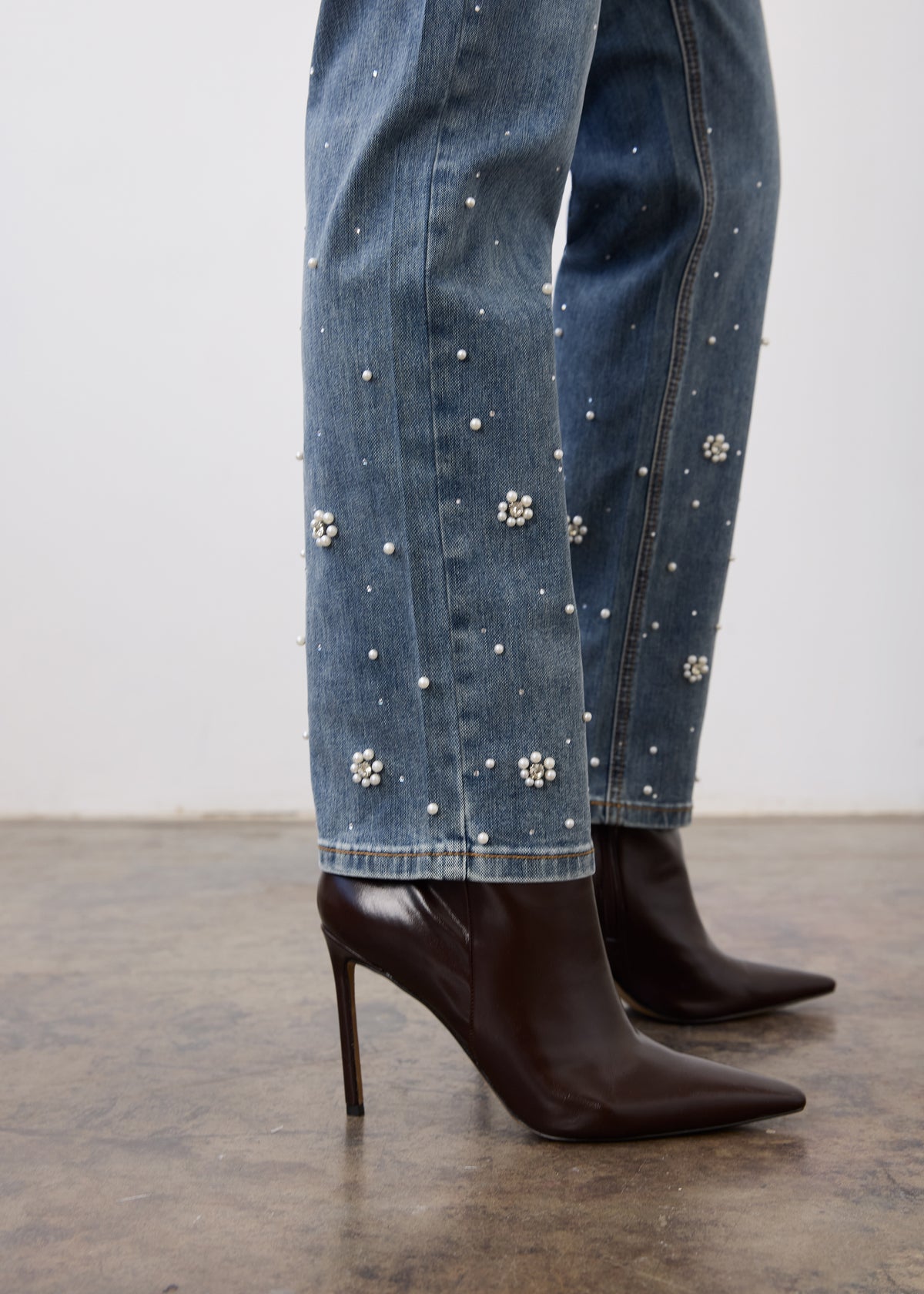 Close-up of indigo jeans fabric showing pearl embellishments on leg by French Dressing Jeans (FDJ)