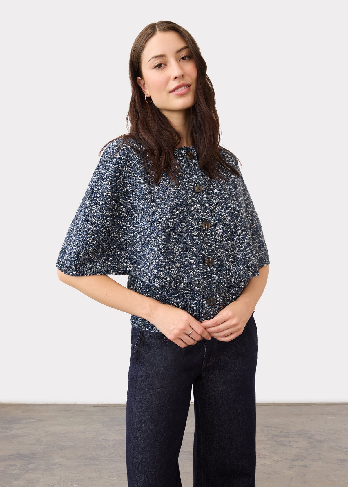 Detail shot of a textured blue knit top paired with dark wash denim showing button closure by French Dressing Jeans (FDJ)
