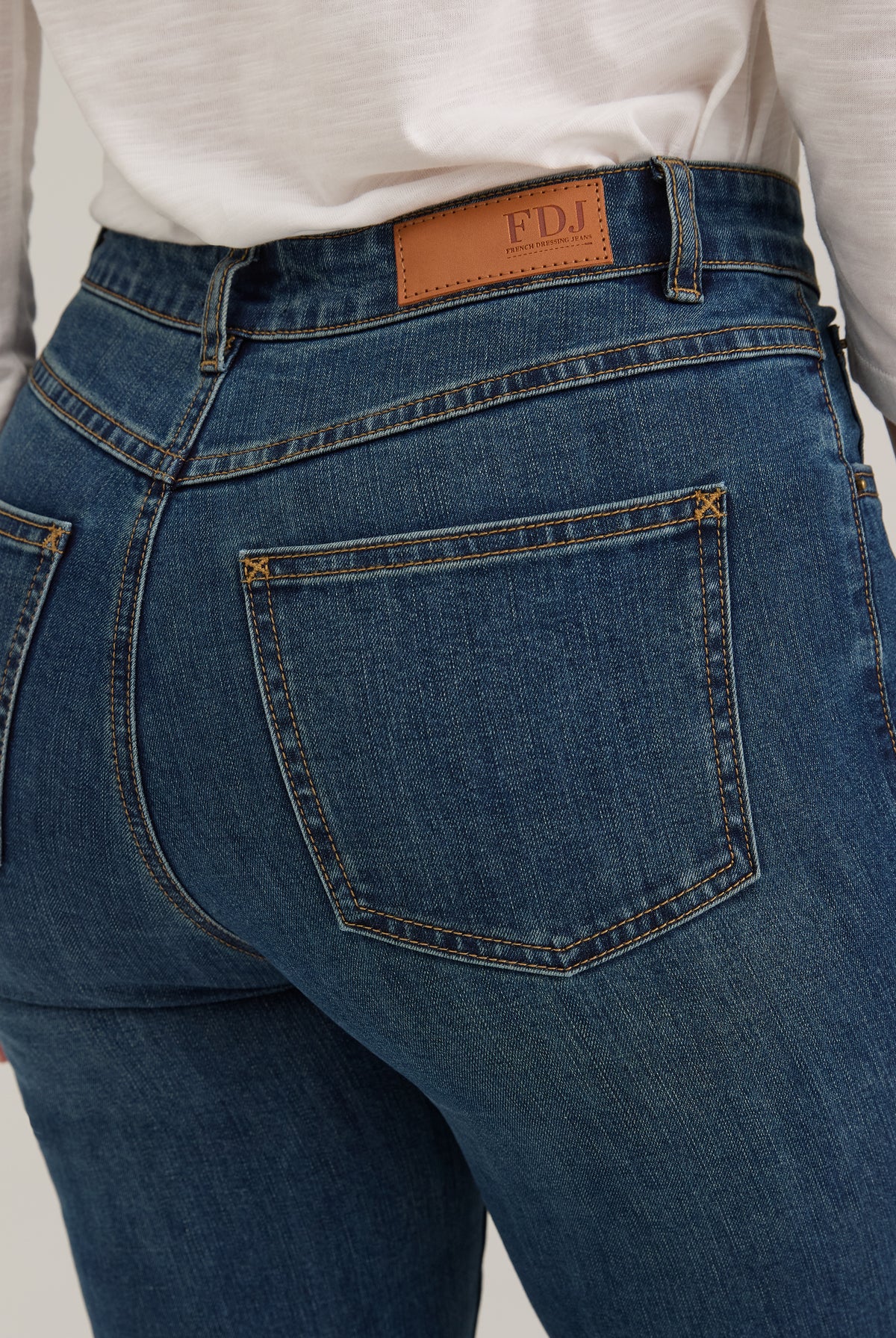 Detail shot of back pocket stitching and FDJ label on dark wash jeans by French Dressing Jeans (FDJ)