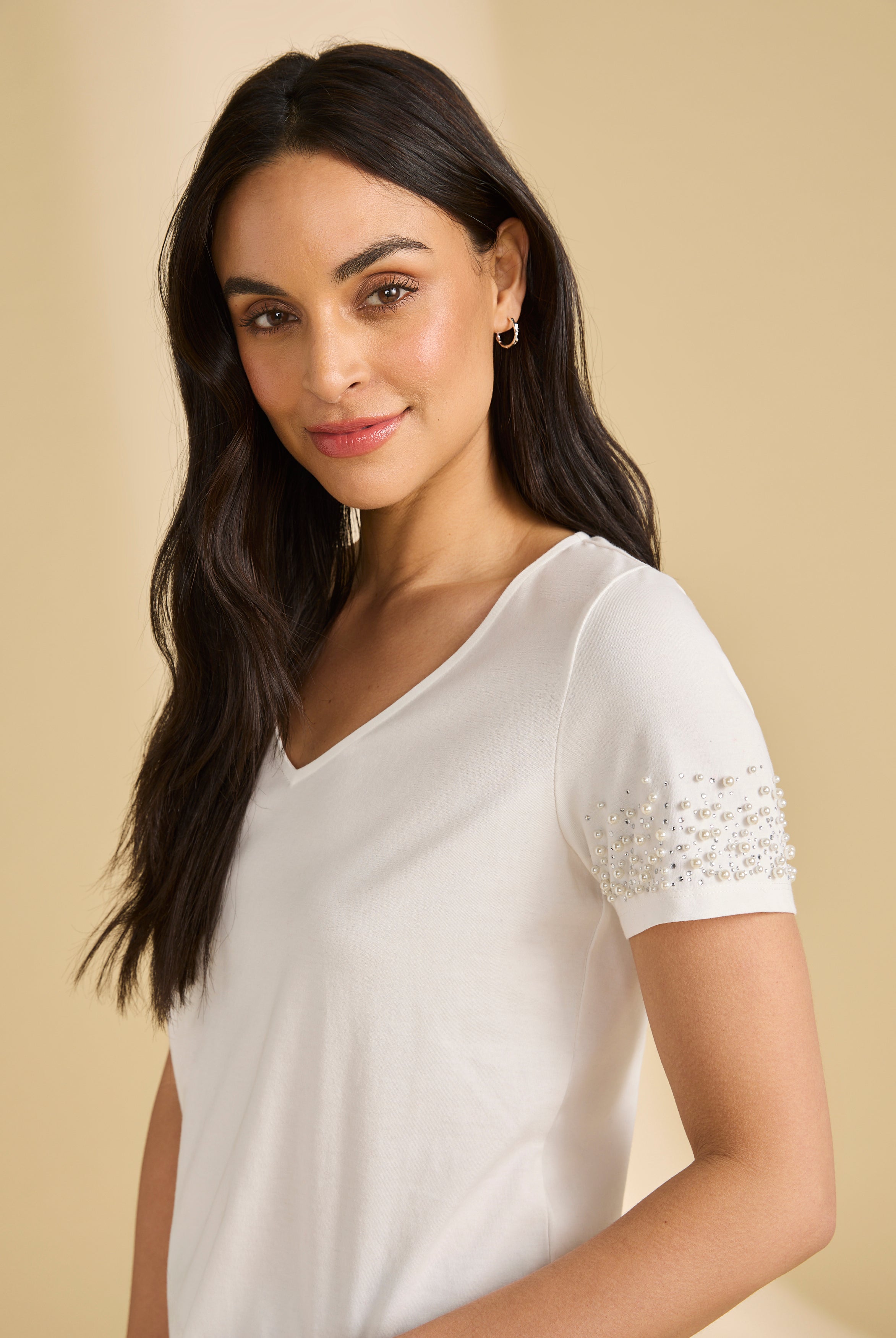 Close-up side view of white V-neck top highlighting pearl details on sleeves by French Dressing Jeans (FDJ)