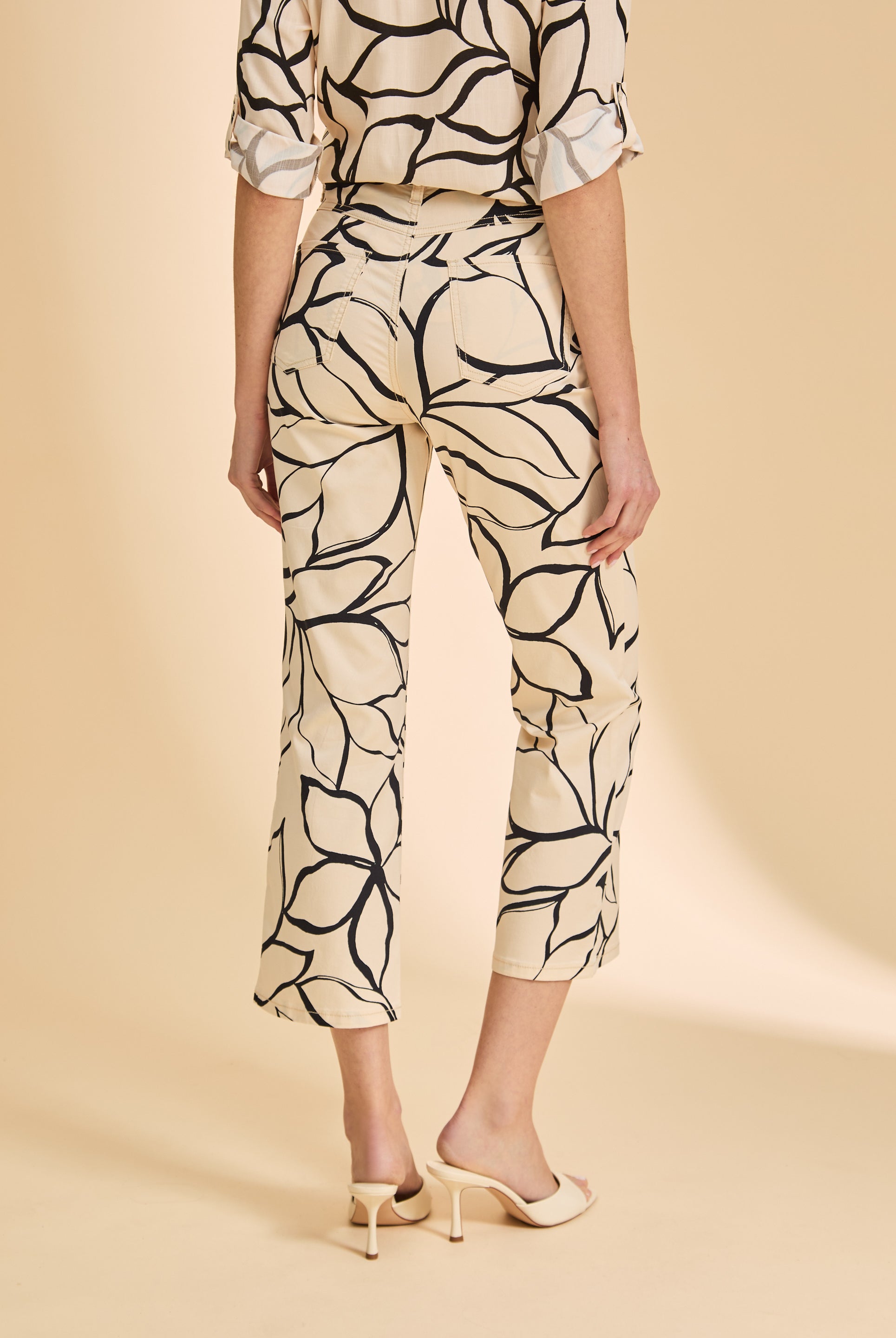 Back view of beige plumeria crop pants showing patch pockets and floral print by French Dressing Jeans (FDJ)