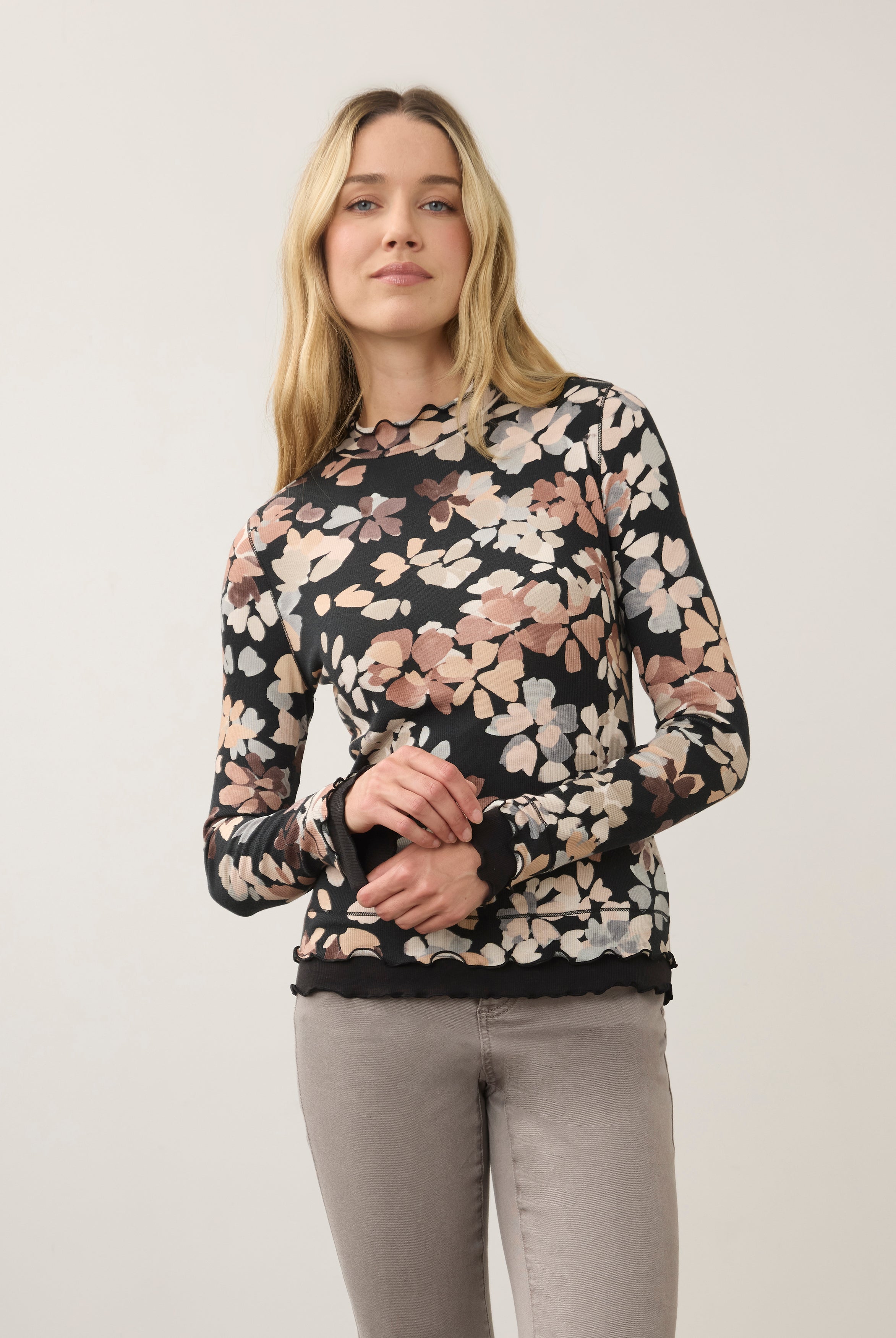 Front view of floral black top with scalloped edges, paired with gray jeans by French Dressing Jeans (FDJ)