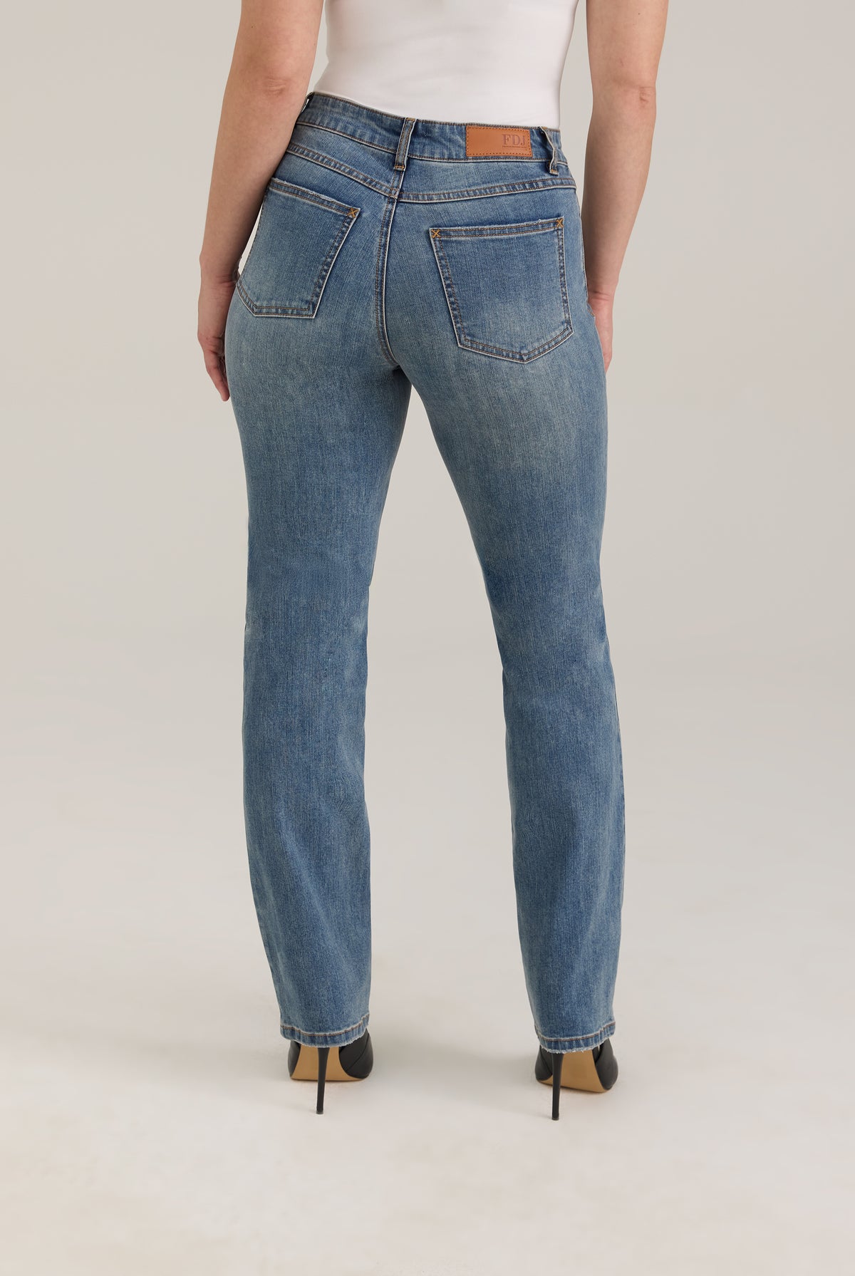 Back view of Olivia straight leg jeans in light wash featuring back pockets and mid-rise design by French Dressing Jeans (FDJ)