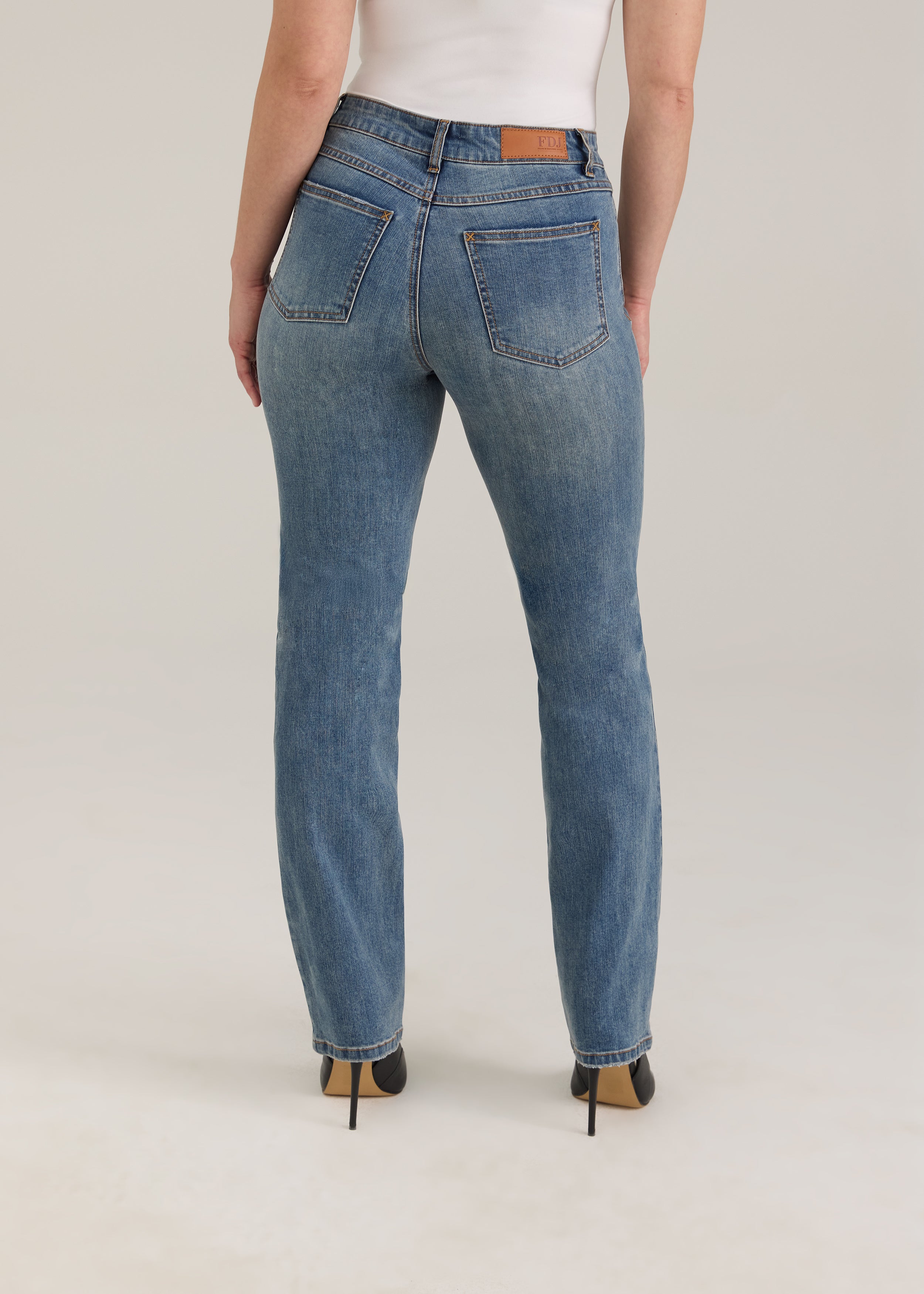 Back view of Olivia straight leg jeans in light wash featuring back pockets and mid-rise design by French Dressing Jeans (FDJ)