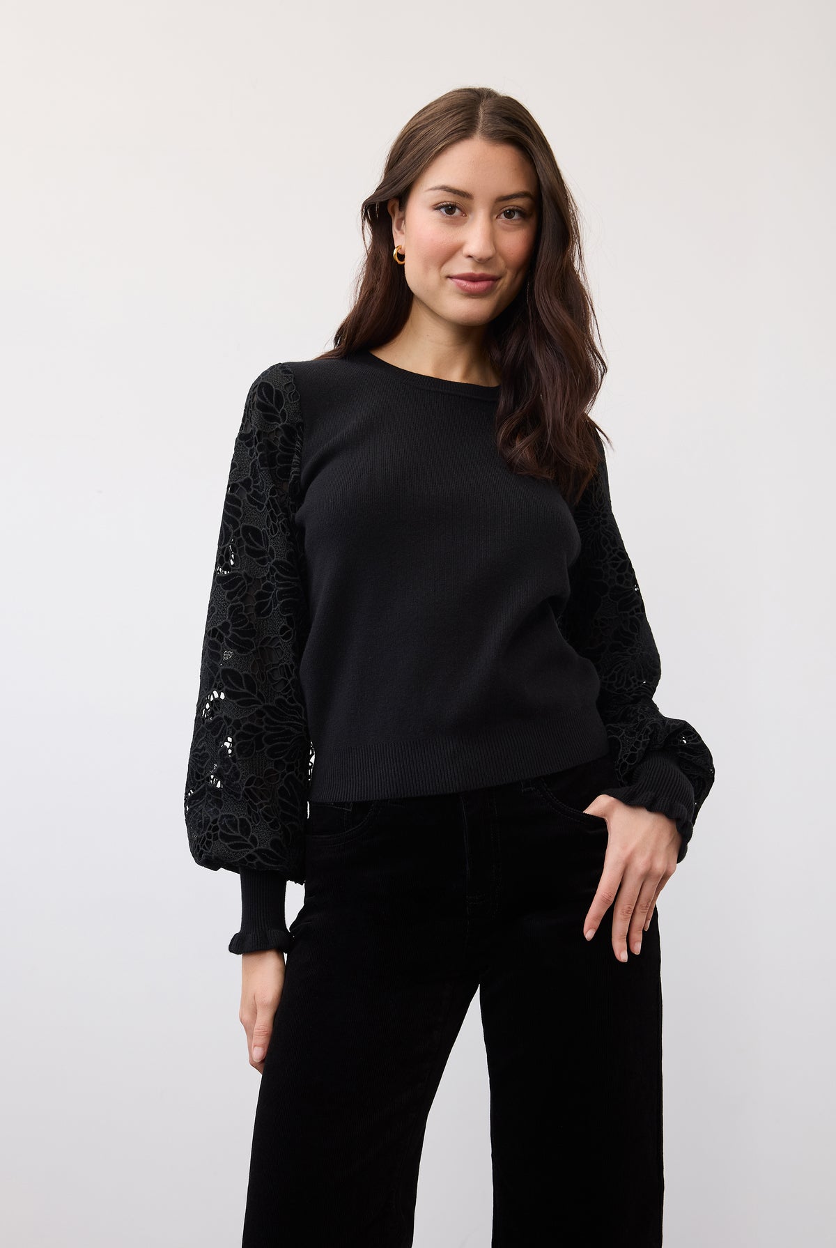 Black sweater showcasing velvet cut-out sleeve details in a standing pose by French Dressing Jeans (FDJ)