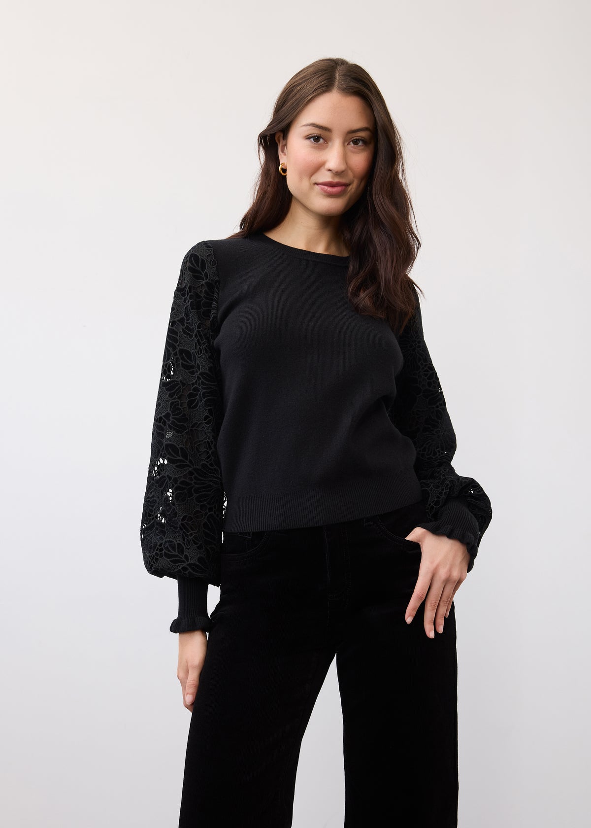 Black sweater showcasing velvet cut-out sleeve details in a standing pose by French Dressing Jeans (FDJ)