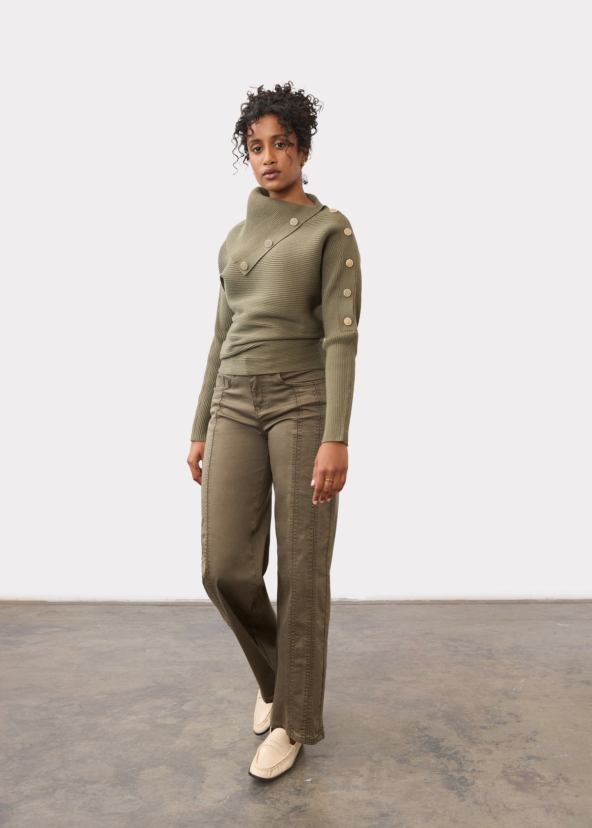Full-length view of model in olive sweater with button accents and matching pants by French Dressing Jeans (FDJ)