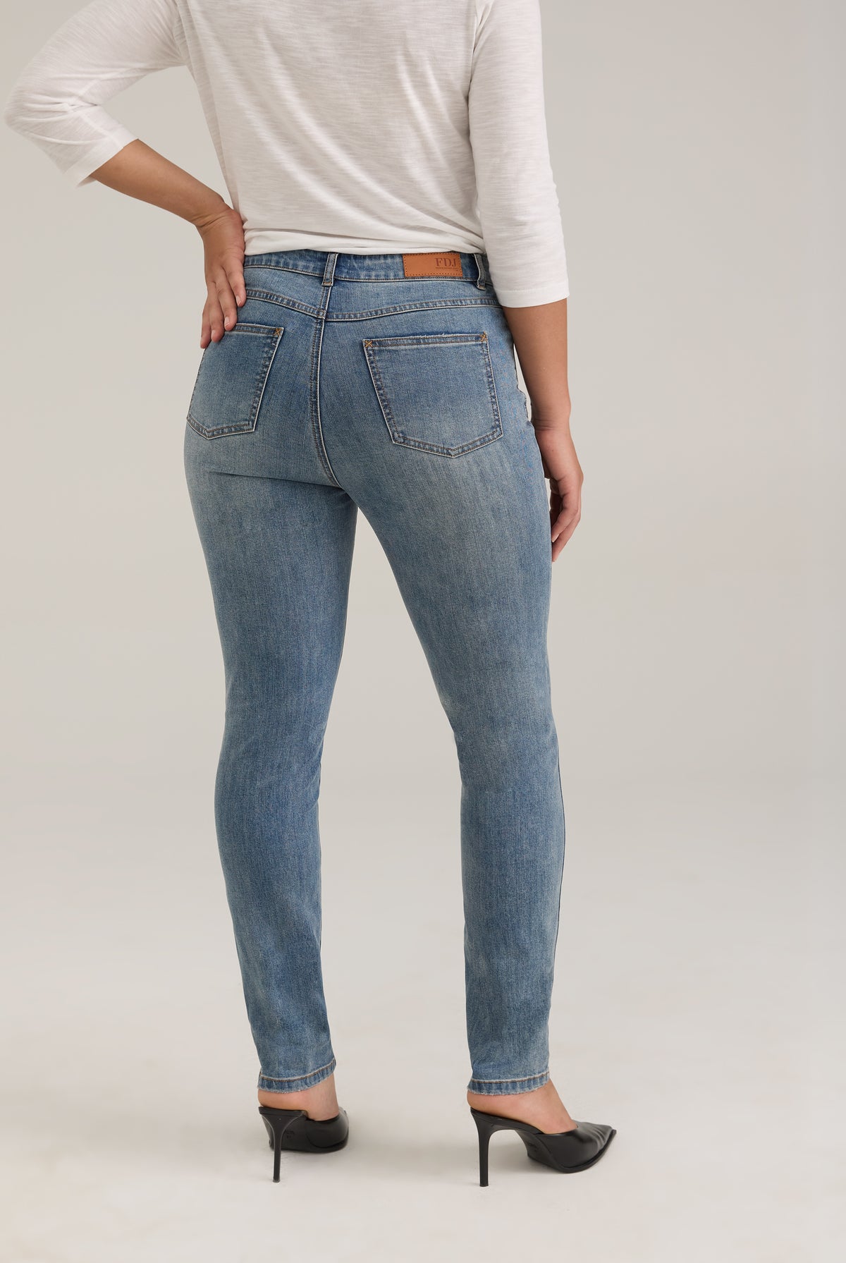 Back view of light wash jeans with back patch pockets and FDJ label by French Dressing Jeans (FDJ)