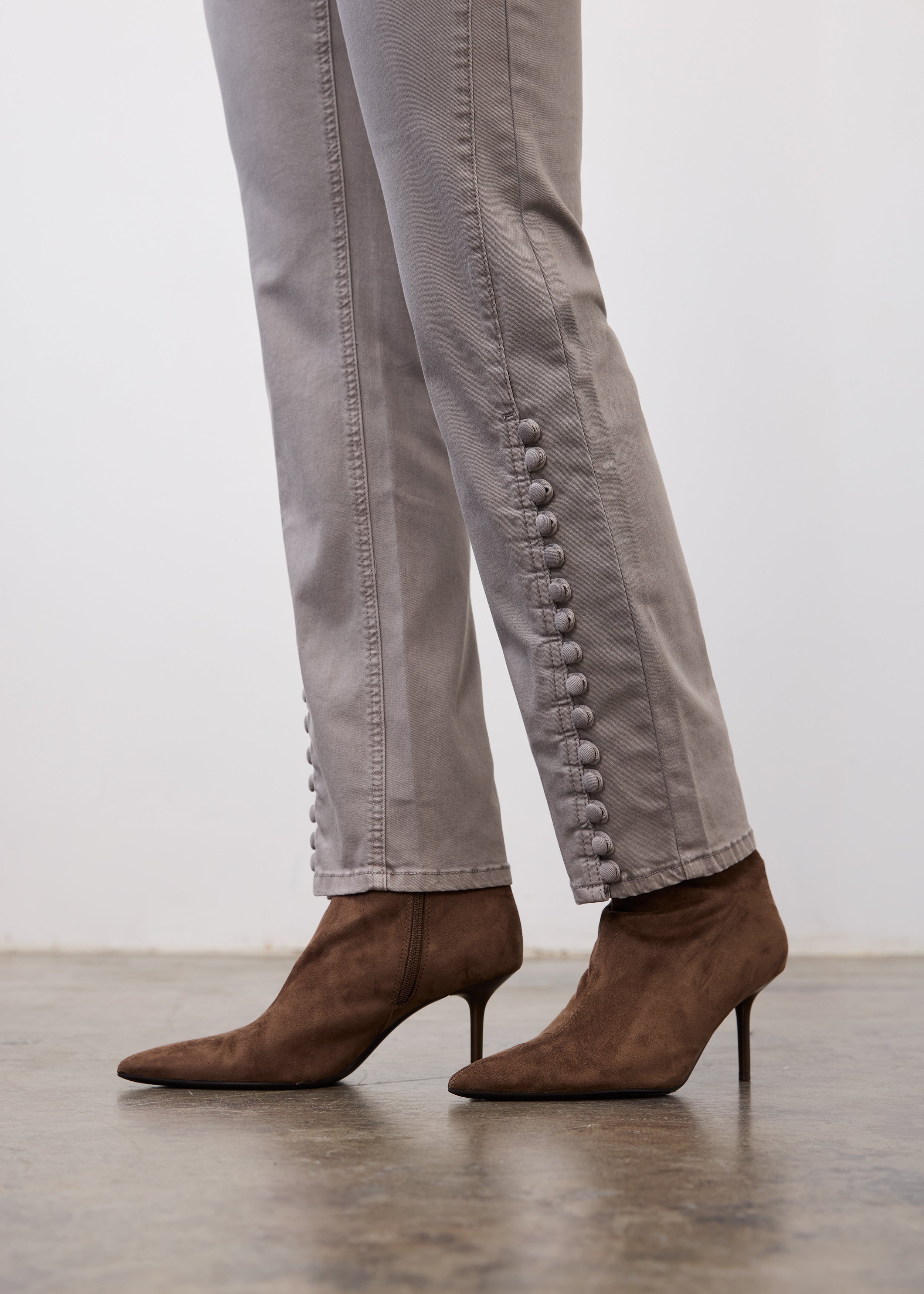 Side profile of gray pencil leg denim highlighting button details on seam by French Dressing Jeans (FDJ)