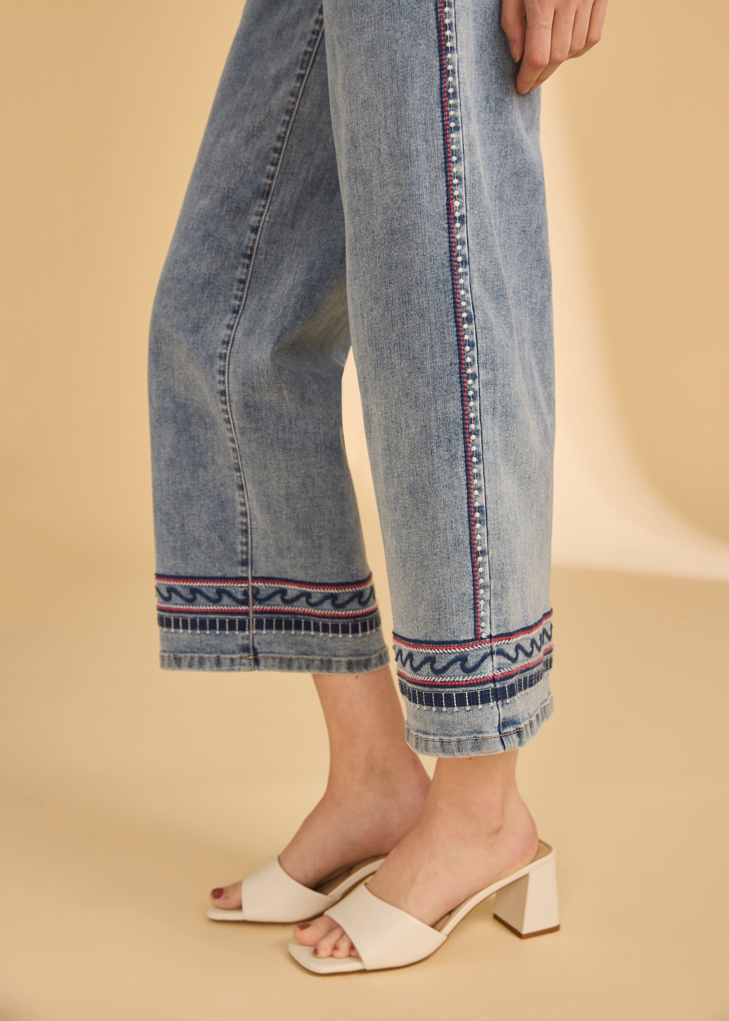 Side view highlighting the embroidered hem on wide leg light medium denim by French Dressing Jeans (FDJ)