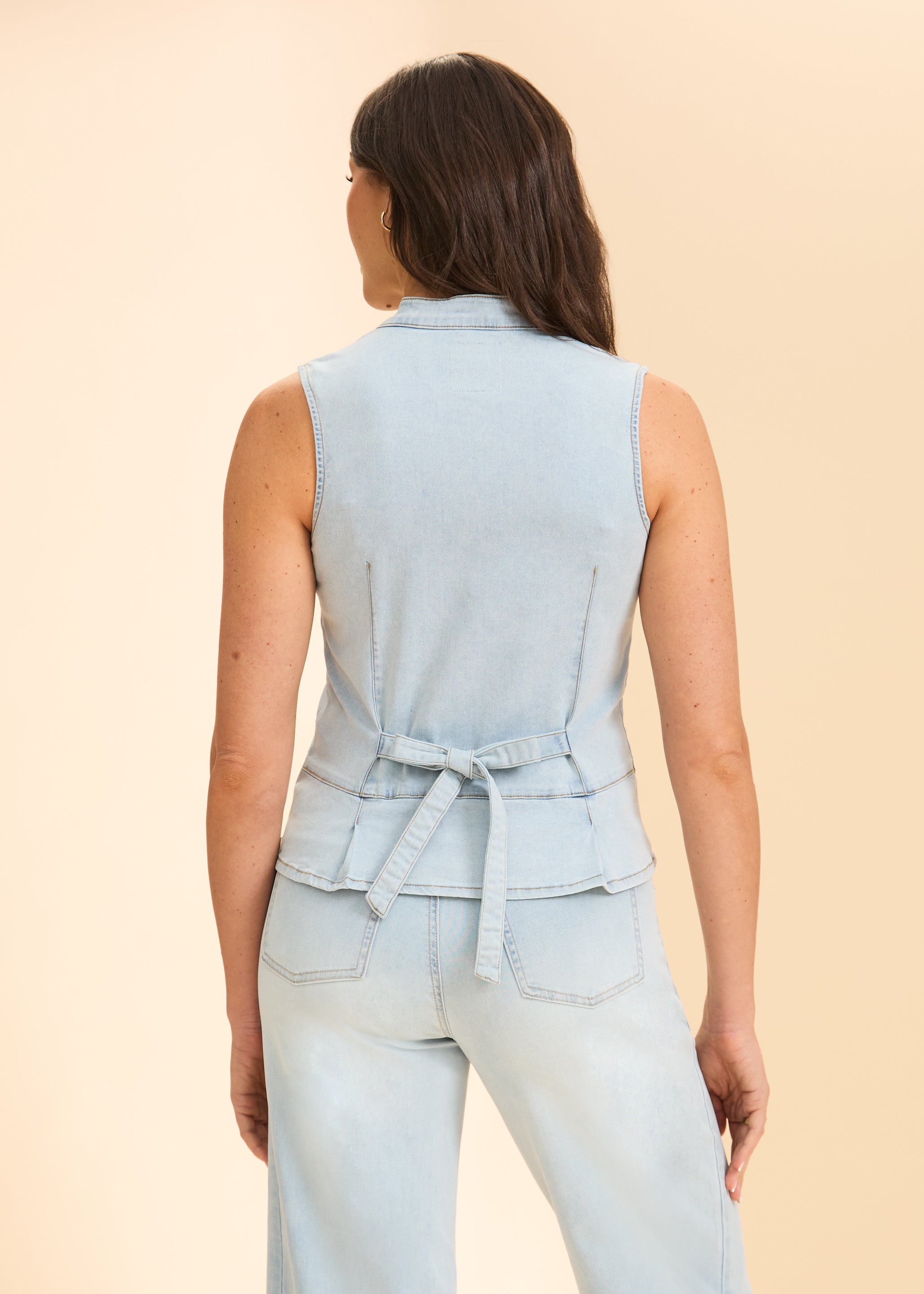 Back view of sleeveless denim top with tie detail and light wash jeans by French Dressing Jeans (FDJ)