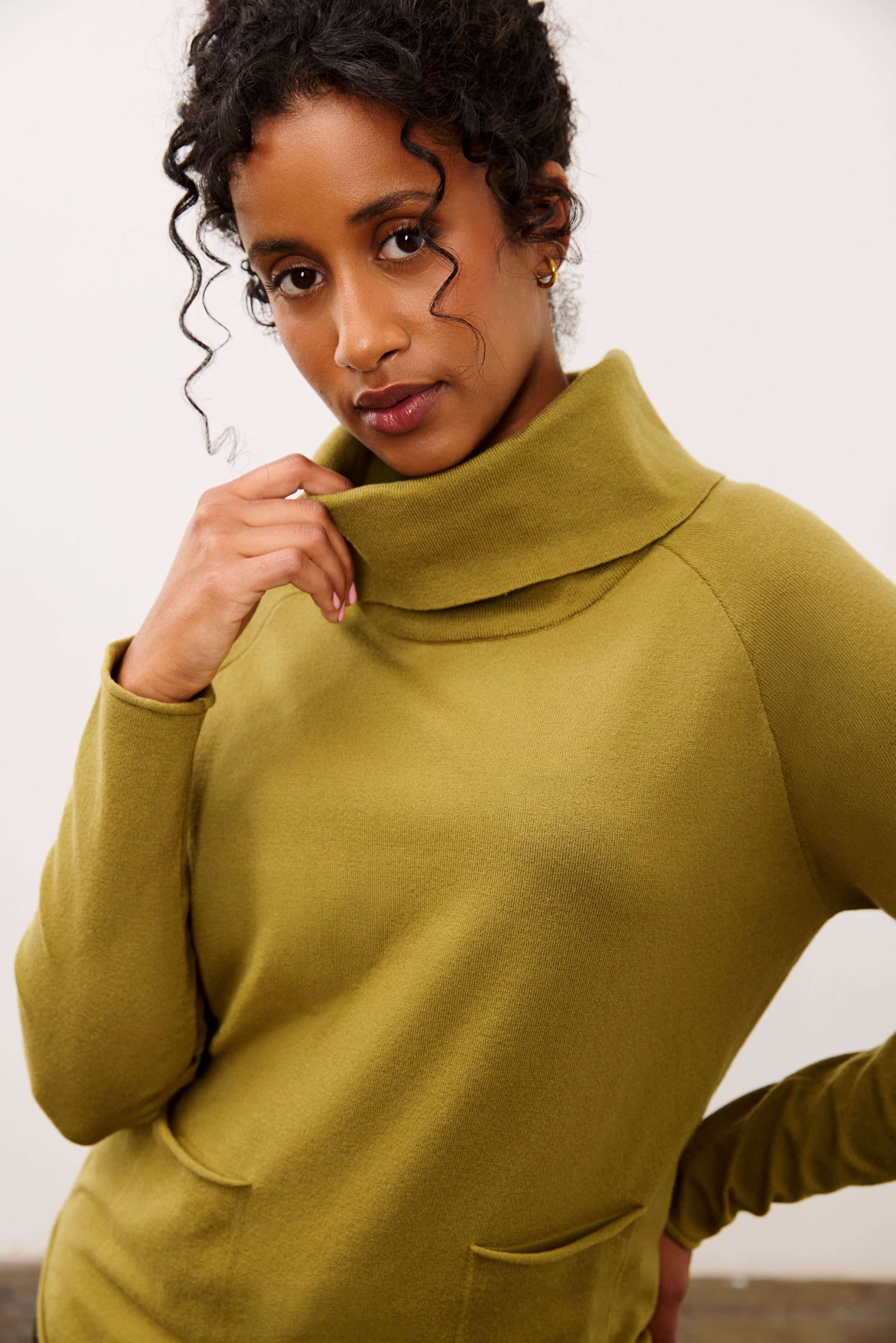 Close-up of olive sweater highlighting cowl neck and pocket details by French Dressing Jeans (FDJ)